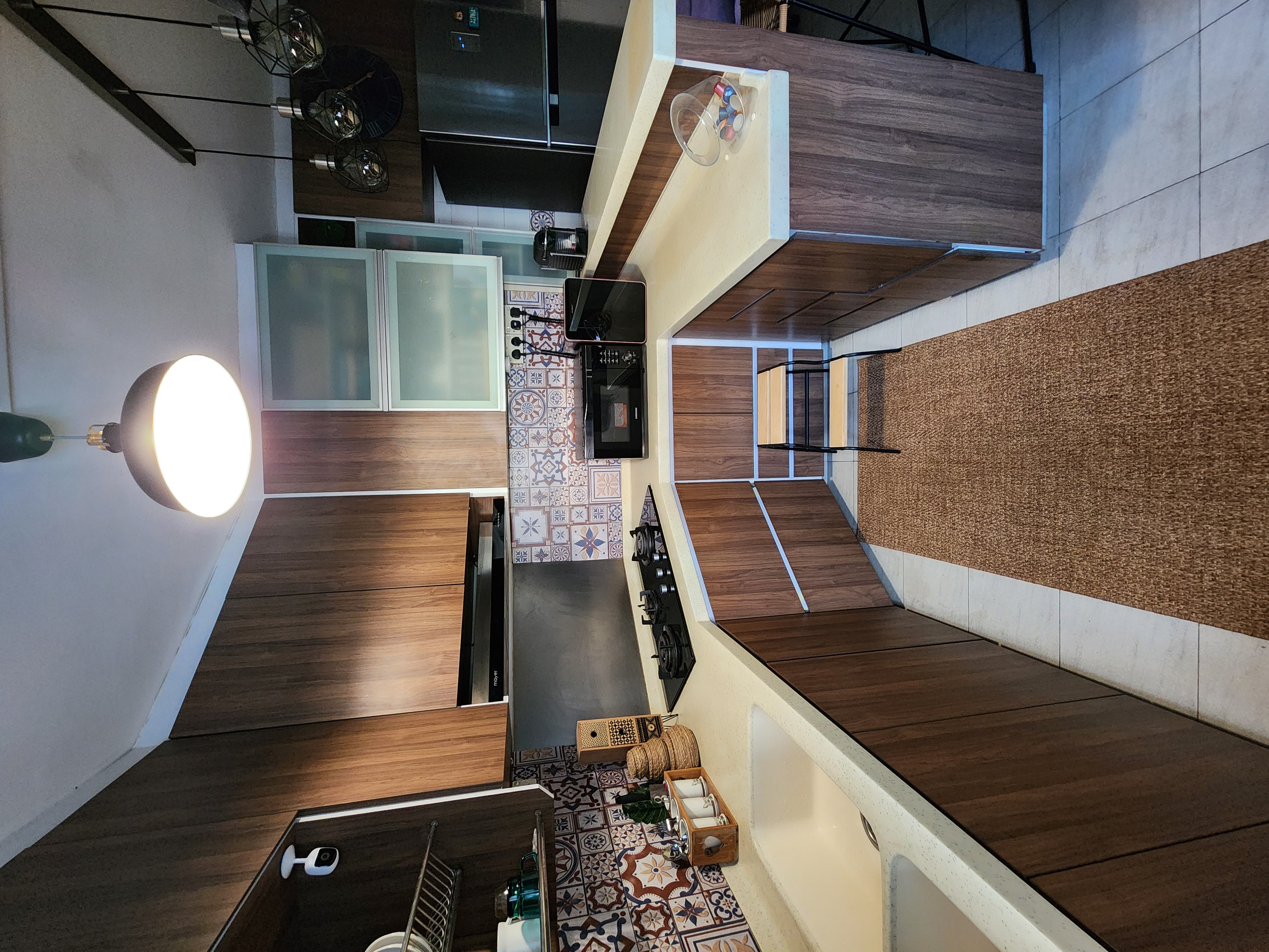 The Earthy Kitchen - Wooden cabinetry, modern kitchen, tiled backsplash, black appliances, open shelving, colorful tiles