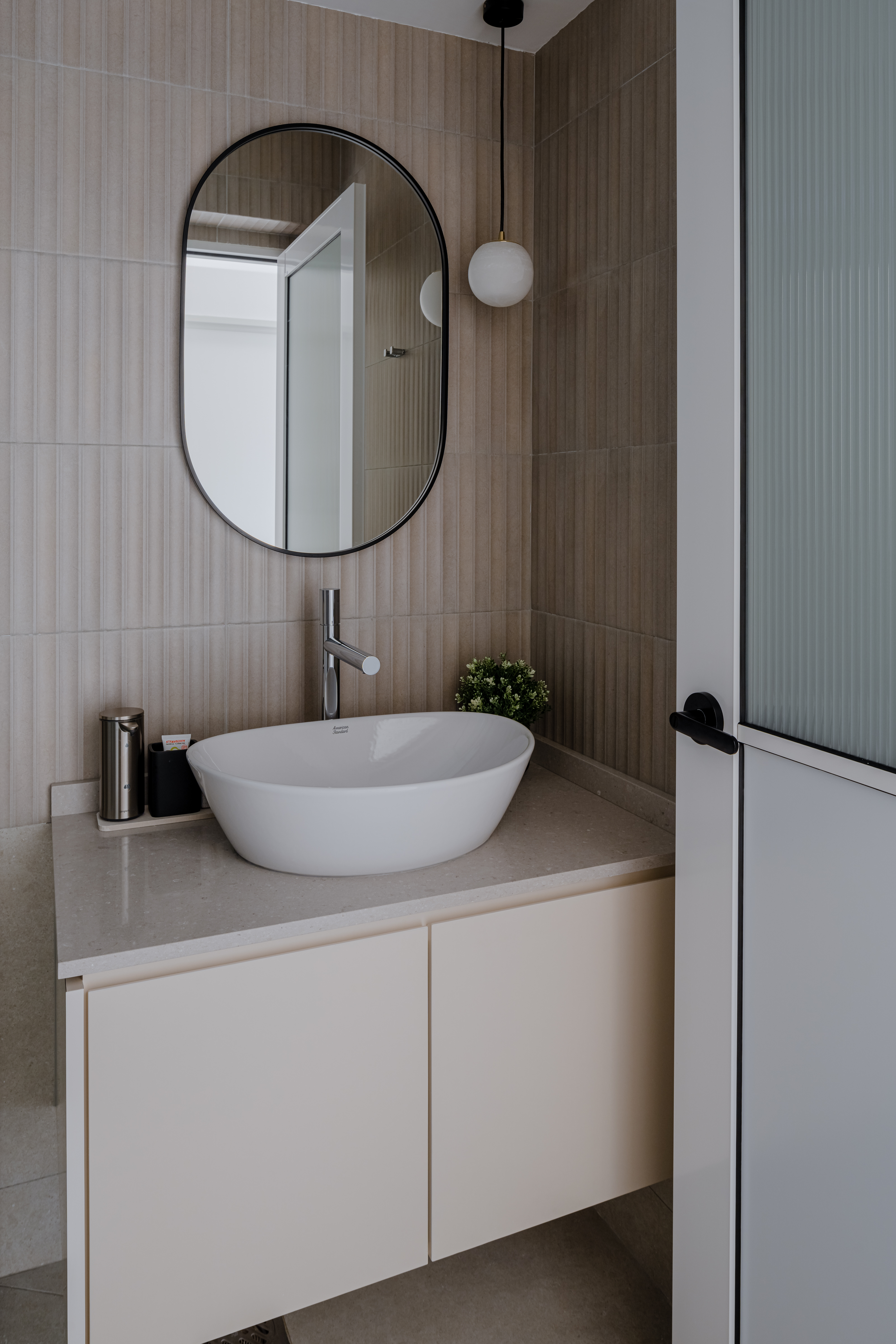 Invigorating Bathrooms That Spark Joy - Modern bathroom with beige tiled walls, sleek white freestanding bathtub, minimalist