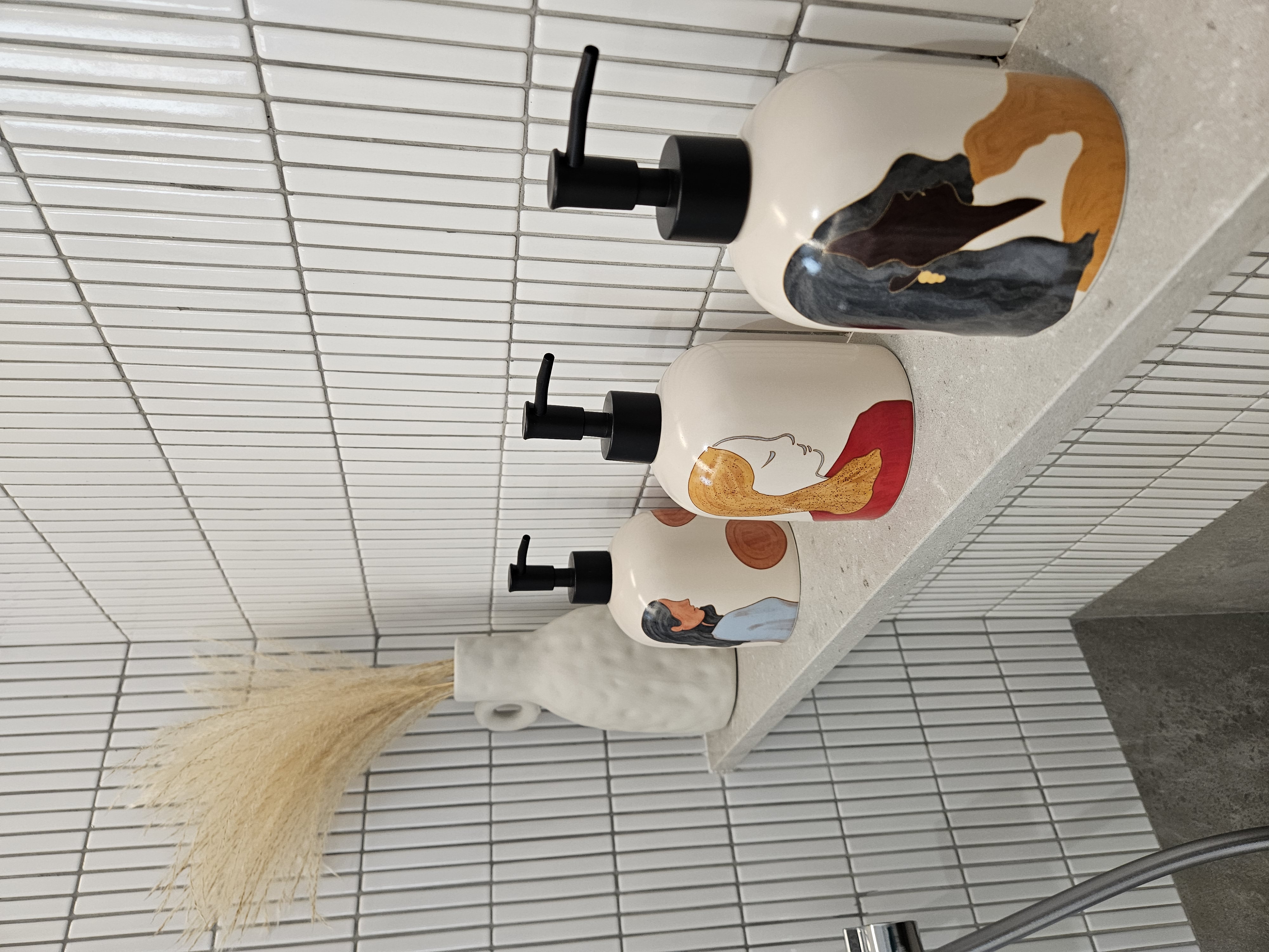 Invigorating Bathrooms That Spark Joy - White tiled wall, modern bathroom, three soap dispensers, minimalist design