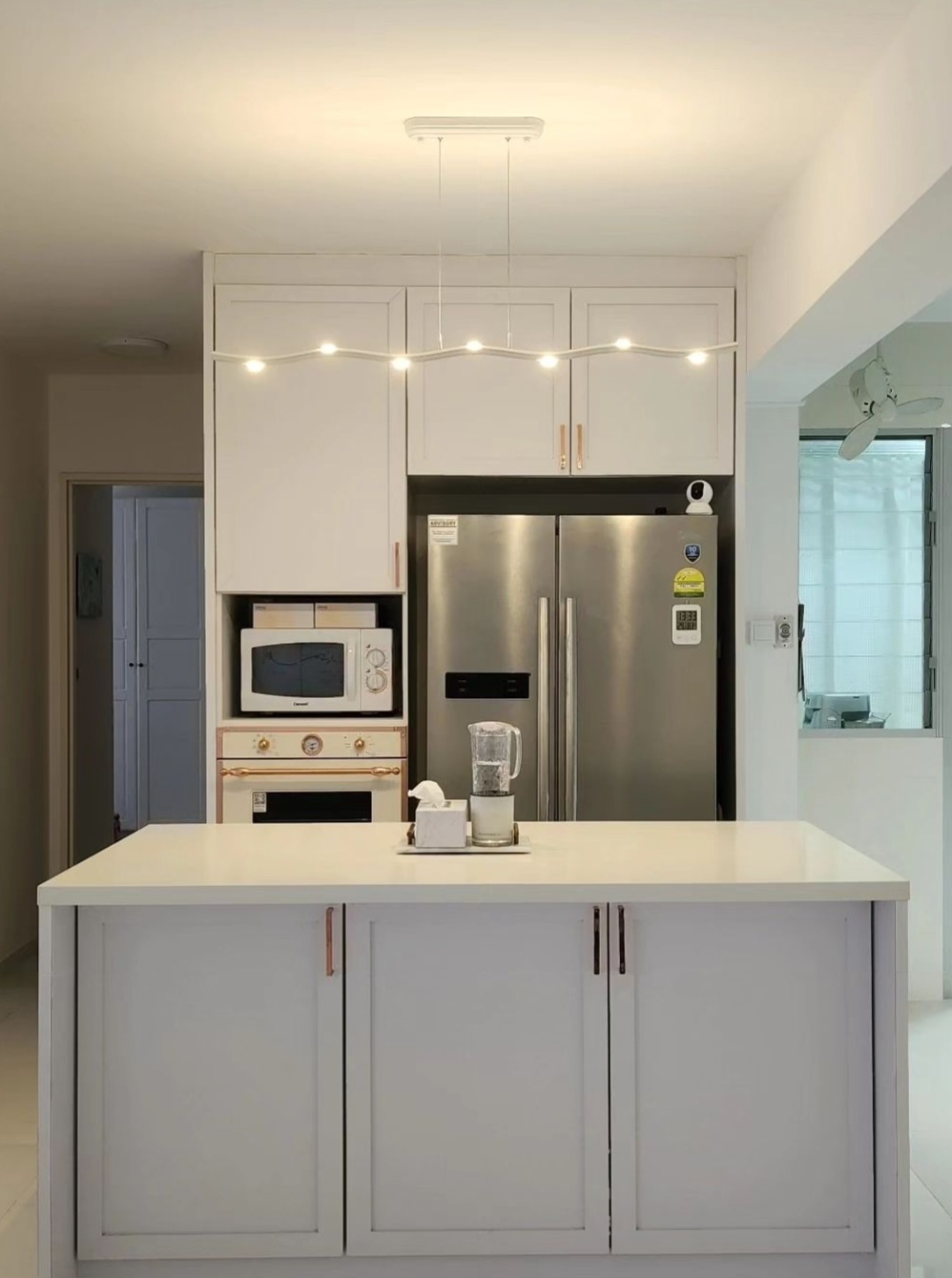 Movable kitchen island shapes the kitchen - White kitchen cabinetry, modern appliances, stainless steel refrigerator, white