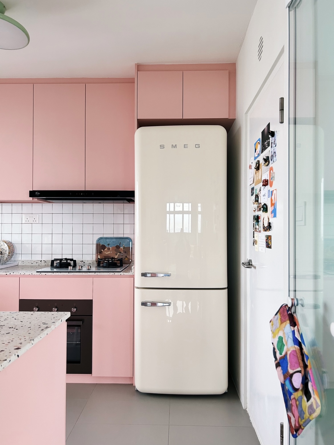 A pink kitchen because why not! - Pink kitchen cabinets, vintage refrigerator, white tiled backsplash, black stove, granite