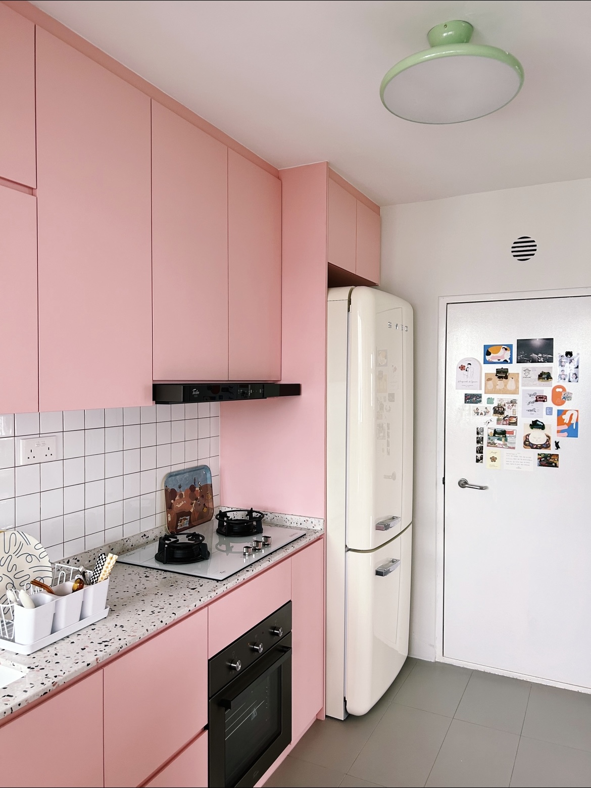 A pink kitchen because why not! - Pink kitchen cabinets, white tiled backsplash, black range hood, white refrigerator
