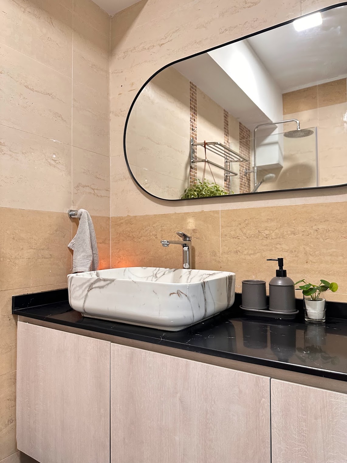 Transforming the Bathroom on a Budget - White marble sink, black countertop, modern bathroom, beige tiles, large mirror