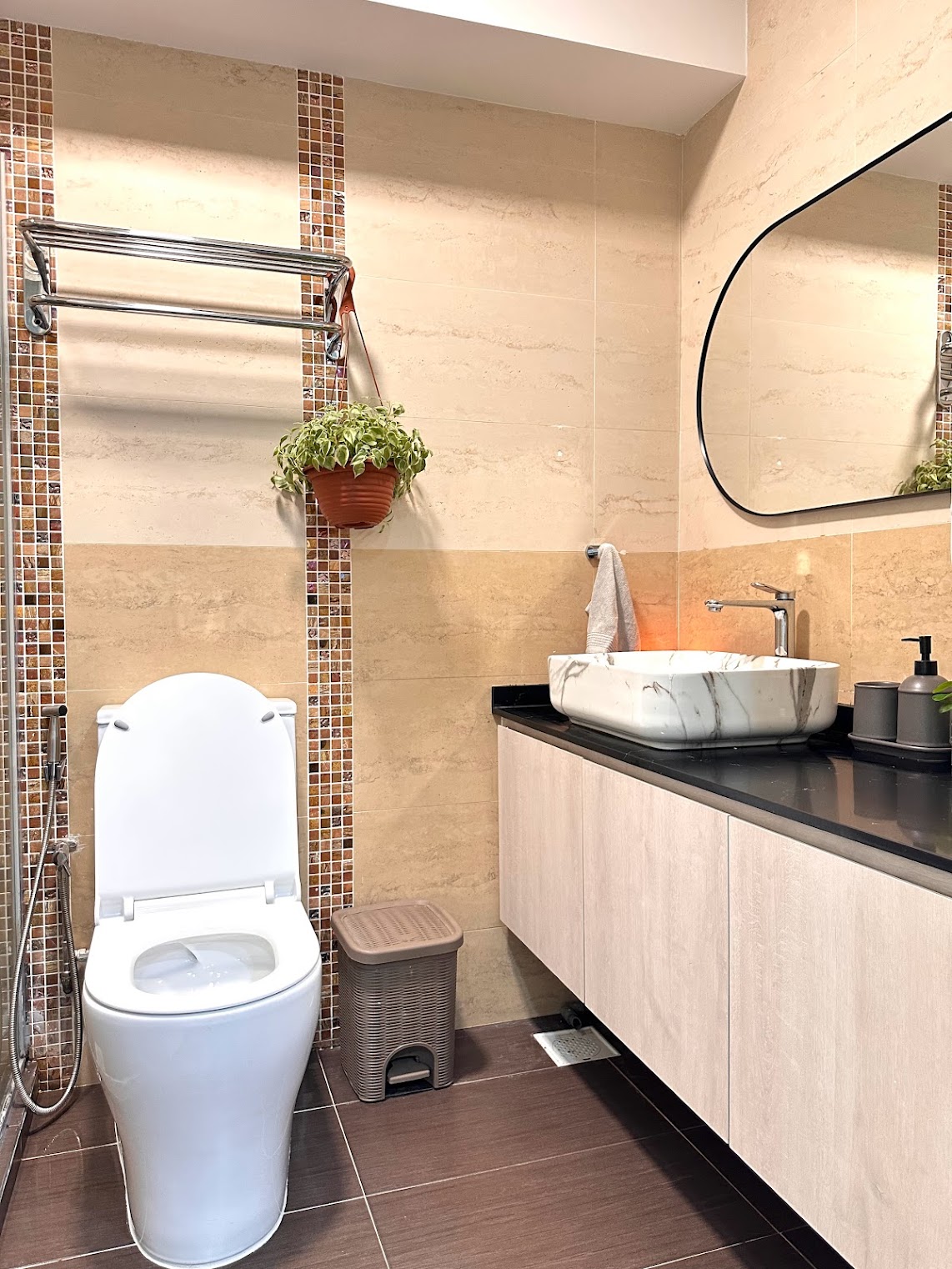 Transforming the Bathroom on a Budget - Modern bathroom with sleek design, beige and brown tiles, white toilet, black