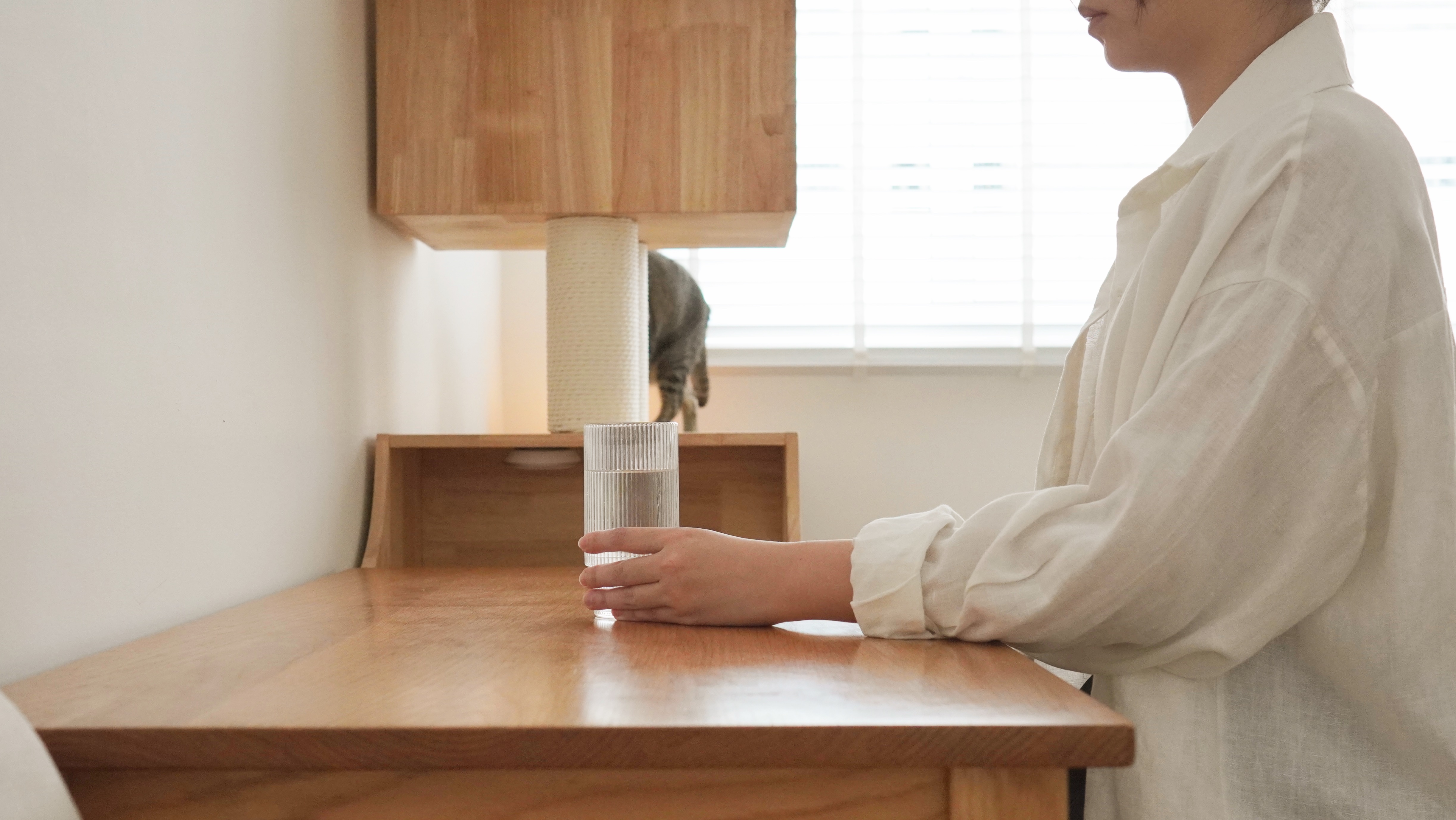 Best Home Purchases After years of Brainstorming - Wooden table, person standing, white shirt, glass of water, cat scratching