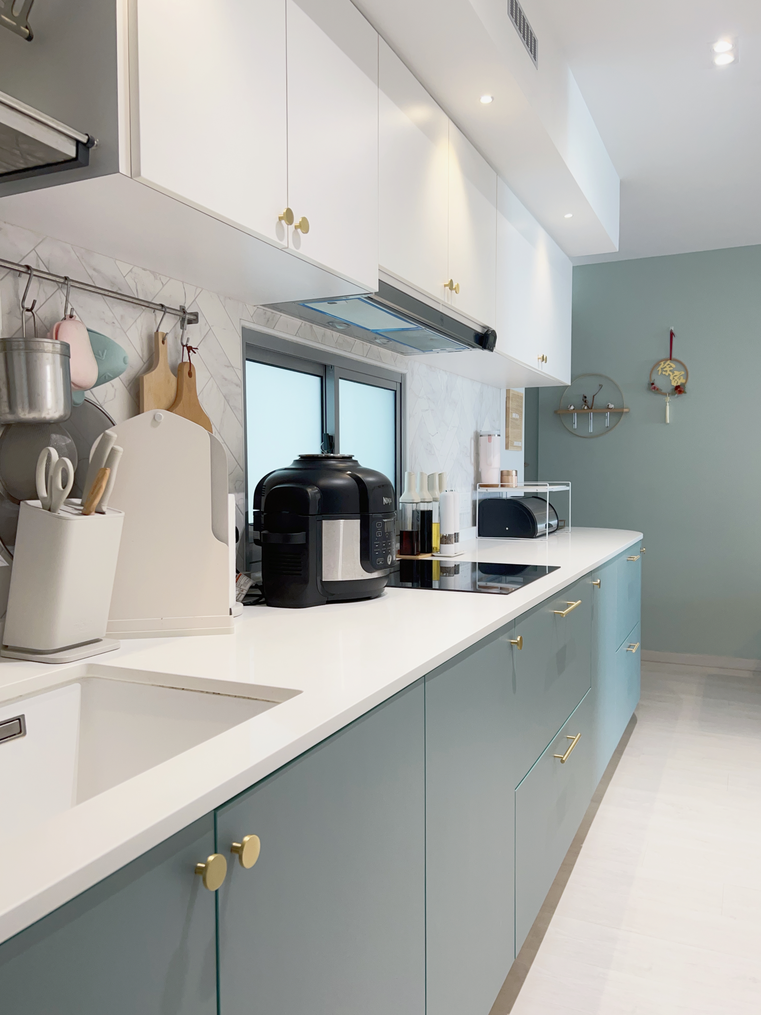 Tips on Organising an Open Concept Kitchen - White kitchen with modern design, light blue cabinets, stainless steel