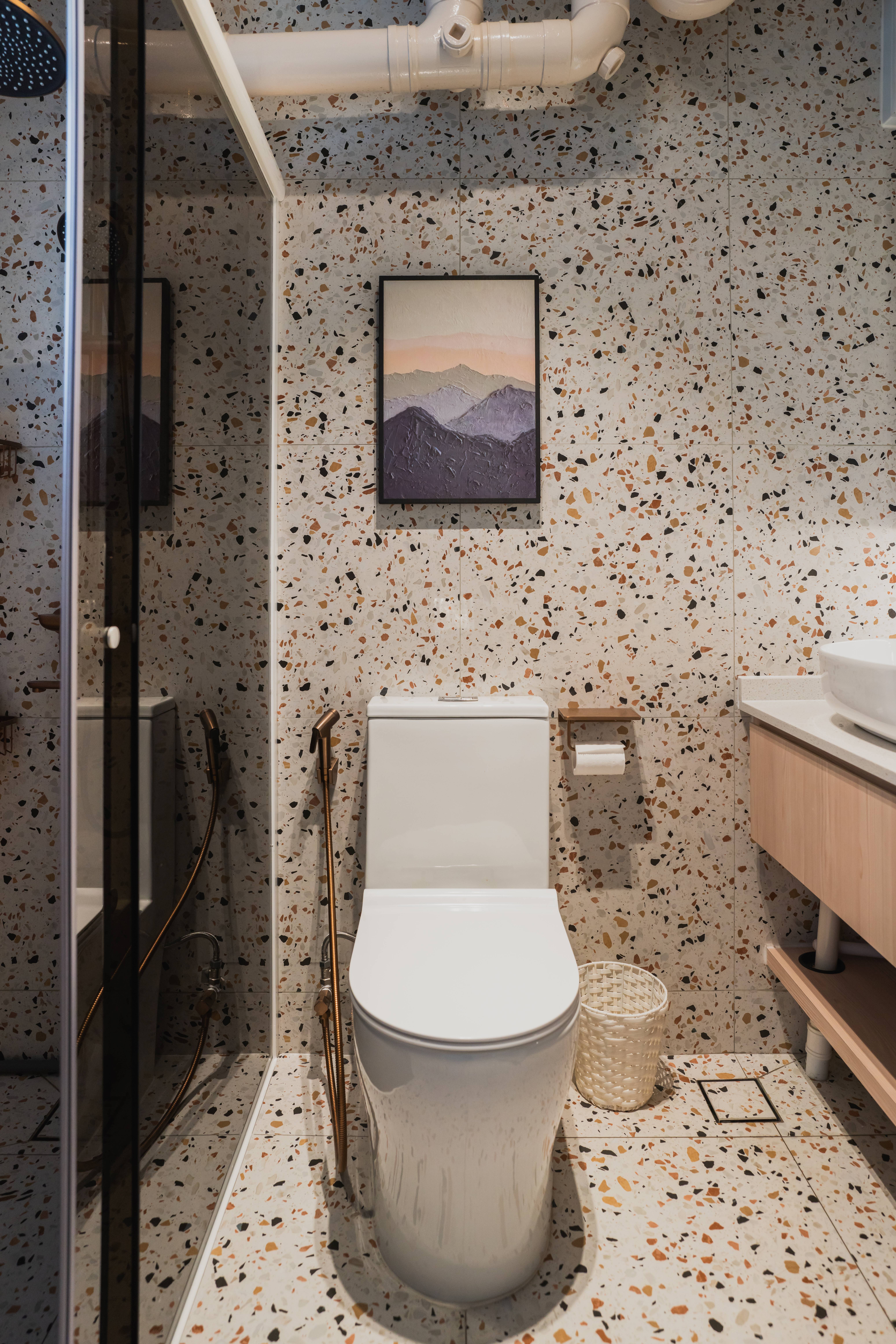 Bathroom edition: Boutique vibes and style  - Modern bathroom with speckled tiles, white toilet, glass shower enclosure