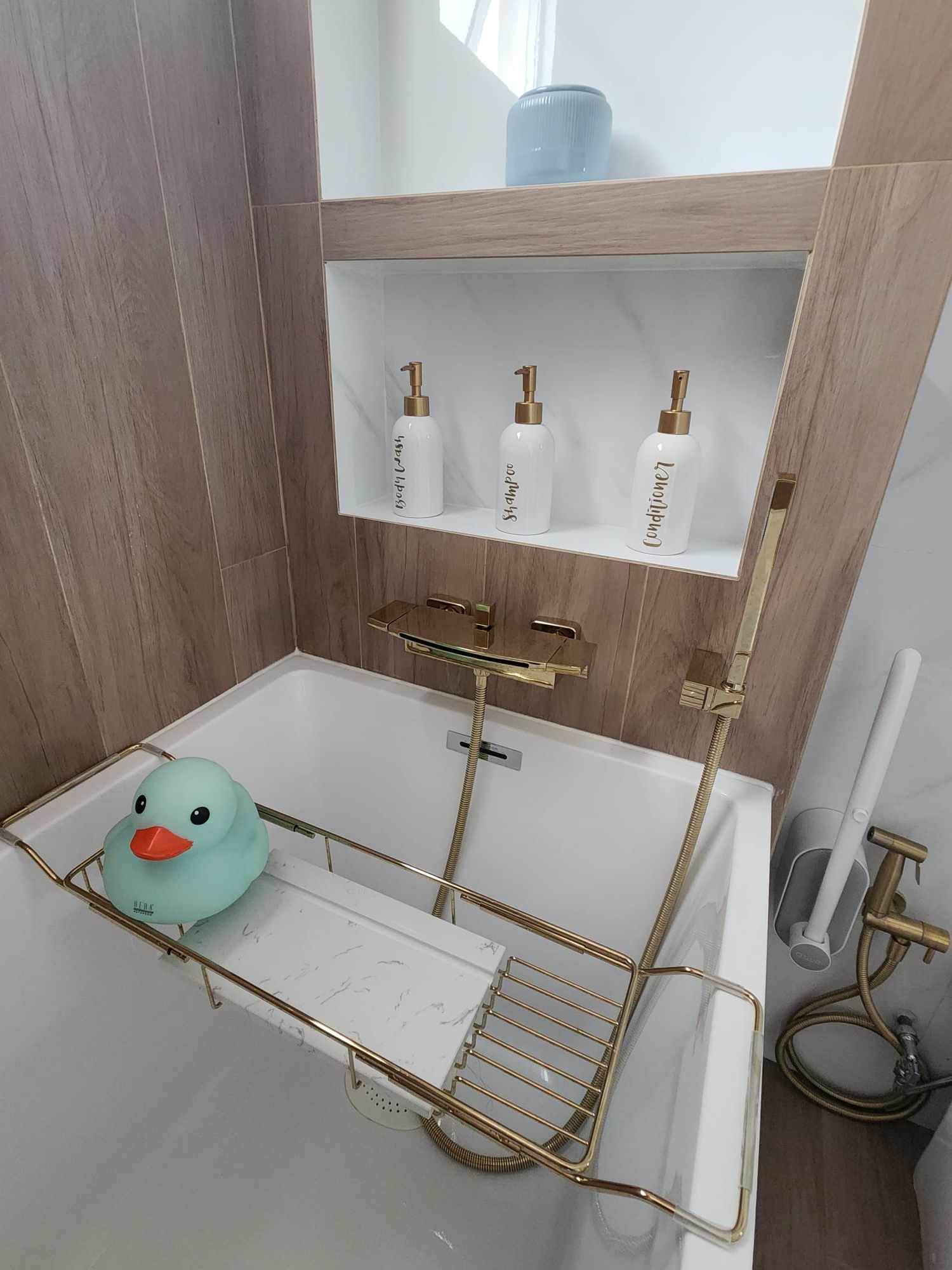Hotel Vibes Bathroom 😍 - Bathtub with gold fixtures, floating tray with rubber duck, wooden wall paneling, white marble