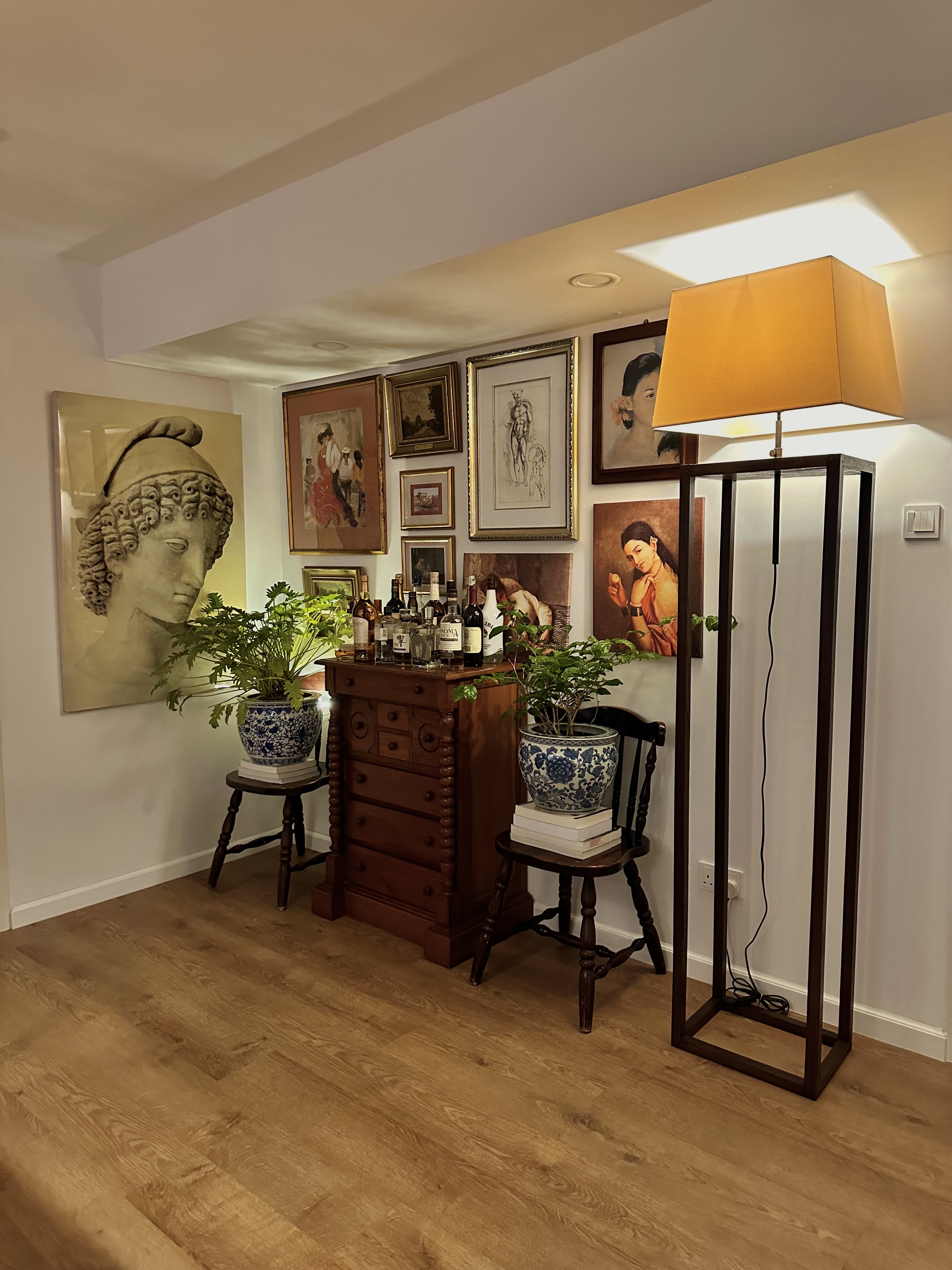 The Magic of Our Home from Day to Night - Greek statue, framed artwork, wooden floor, tall lamp, blue and white vase, wooden