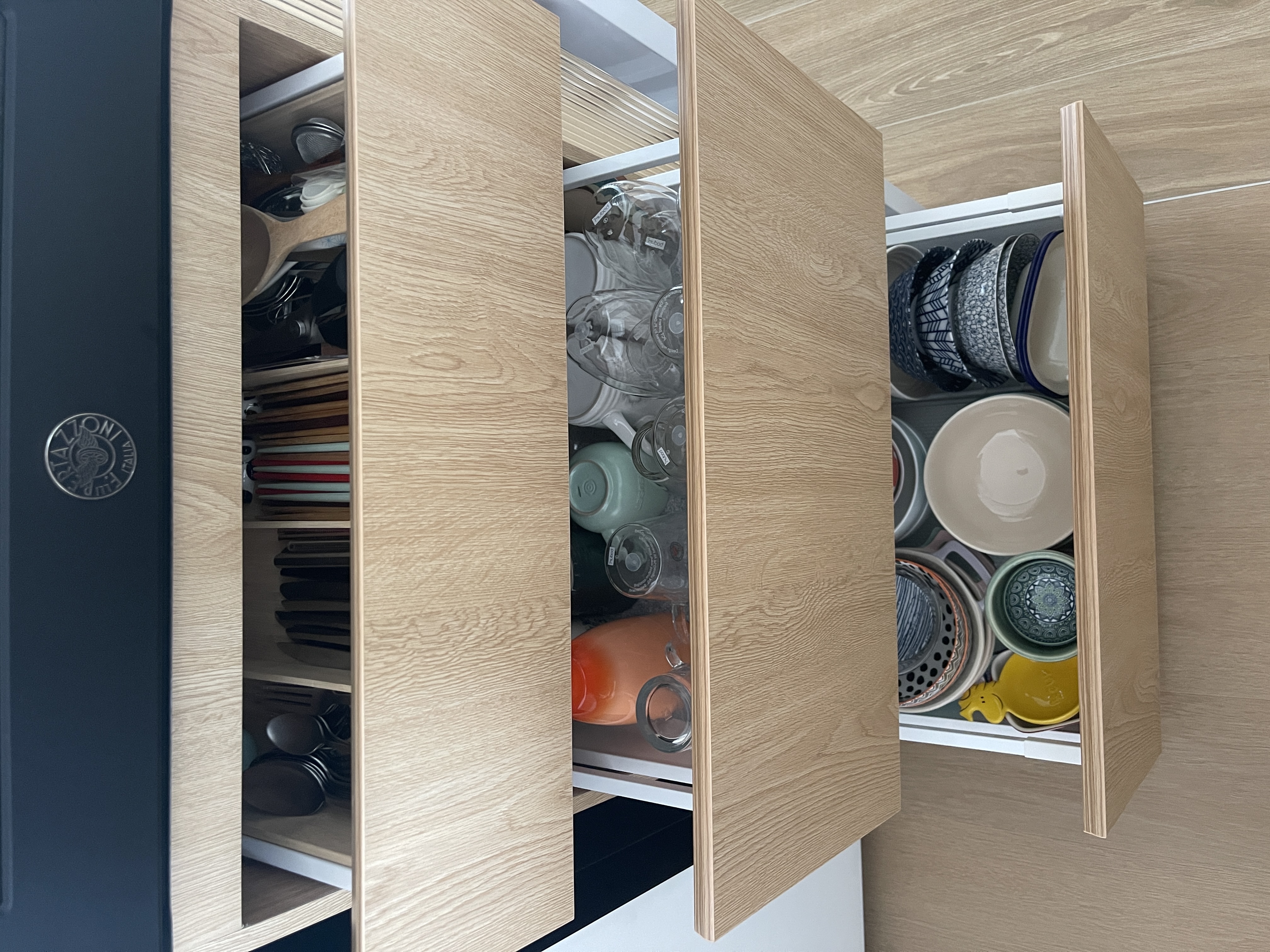 Our Kitchen: Before & After  - Wooden kitchen cabinet, open drawers, neatly organized dishes, glassware, ceramic plates