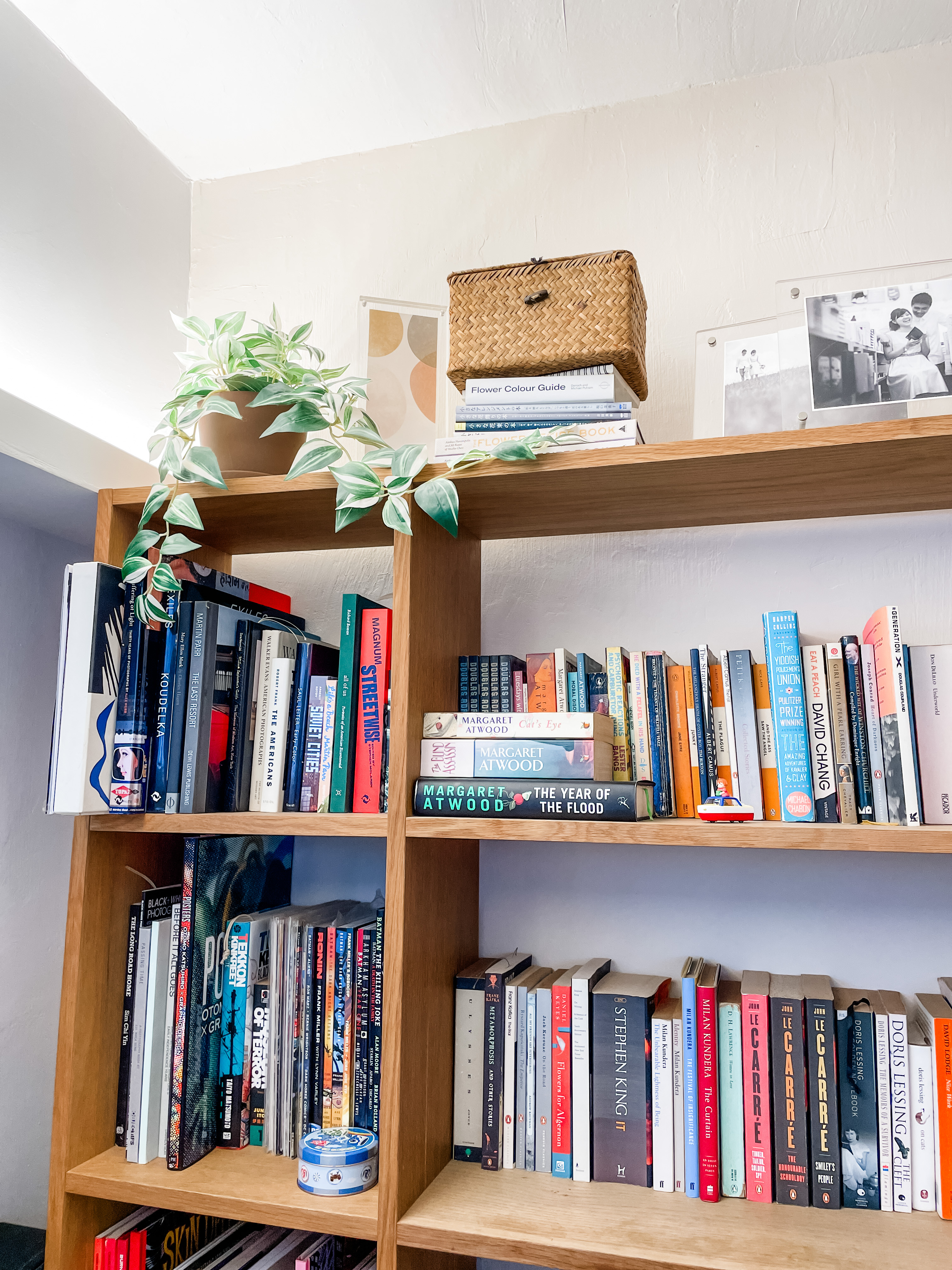 A WFH Workspace Where We Work (And Our Kids Play!)  - Wooden bookshelf, neatly organized books, various genres, diverse