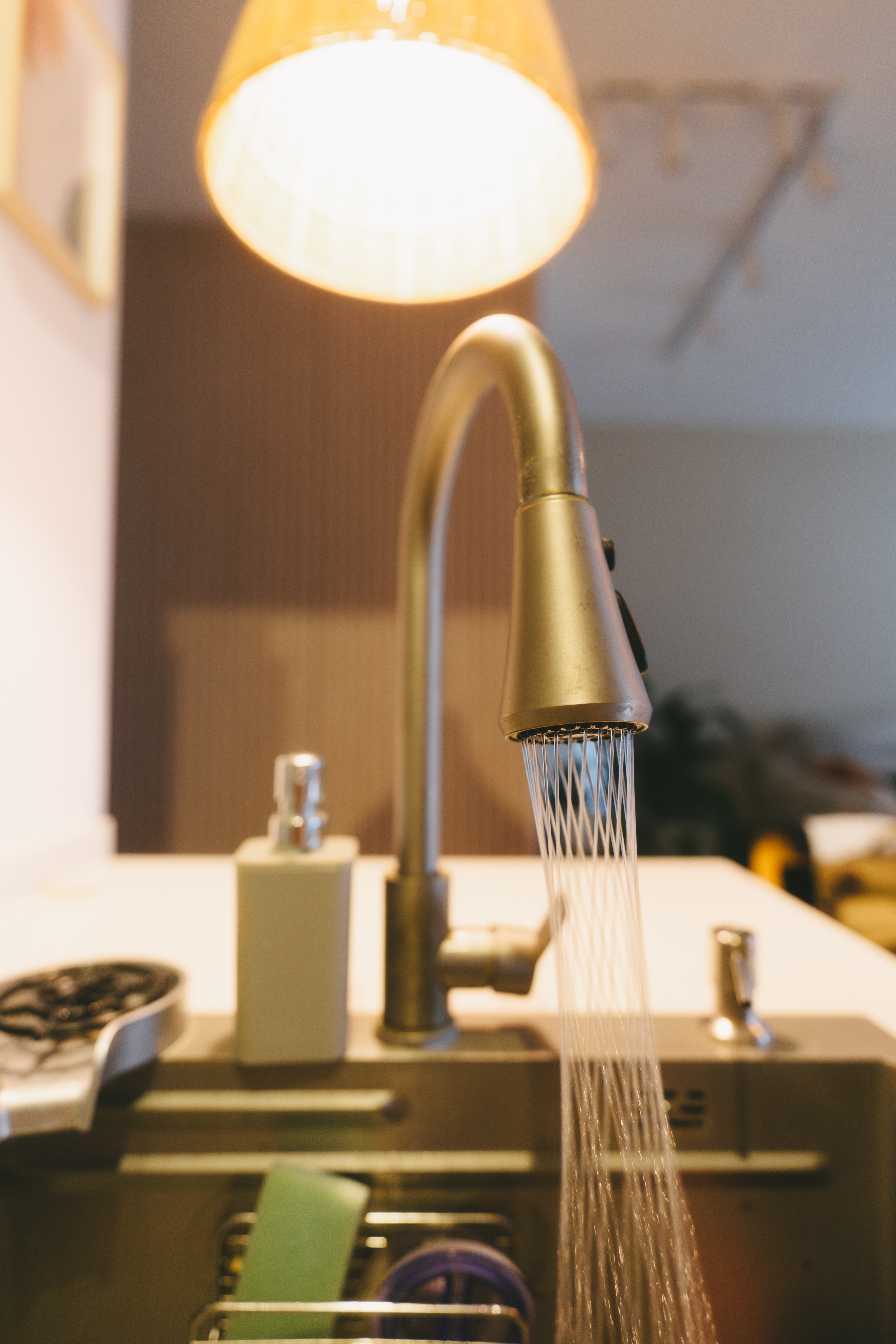 A rather uninspiring kitchen | Thoughts and reflections - Modern kitchen sink with warm light, faucet with water stream