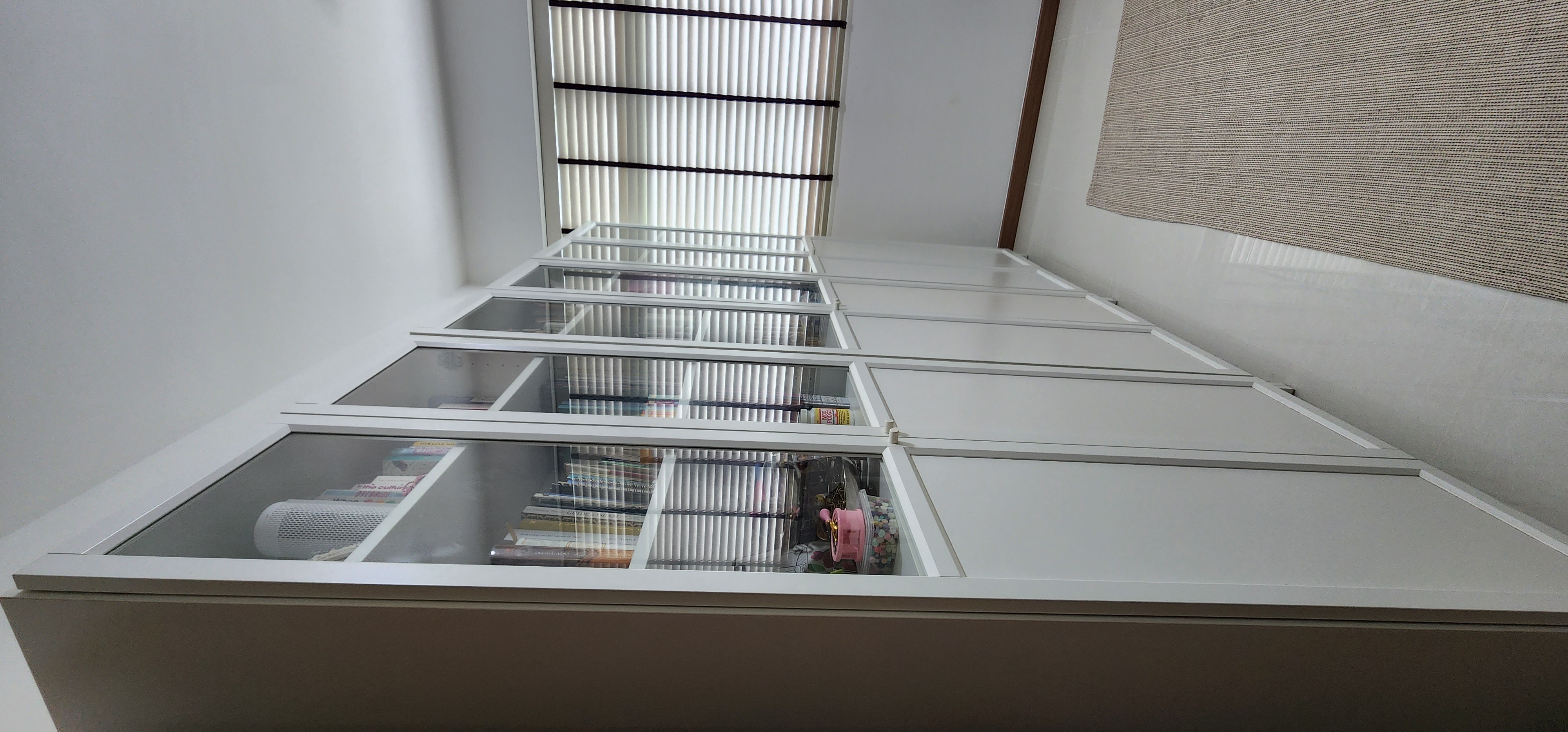 The Qurated Office - Glass shelves, white cabinets, indoor plants, natural light, minimalist design, modern decor, bookshelf