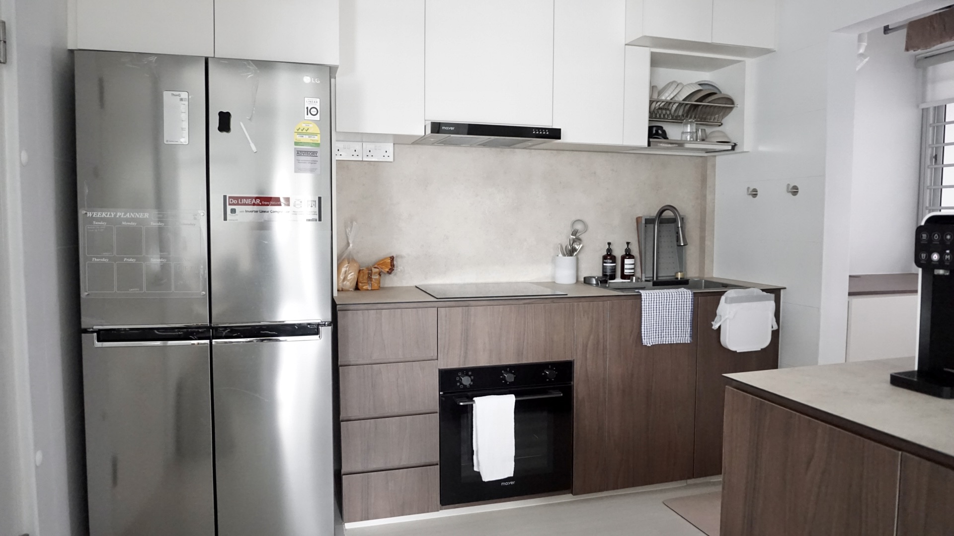 10 feet across, small but sufficiently equipped kitchen - Silver refrigerator with weekly planner, stainless steel kitchen