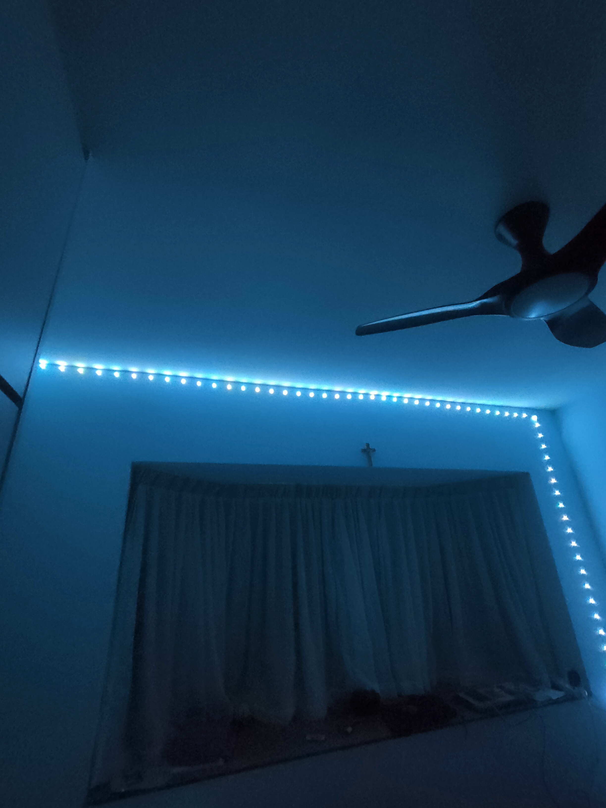 Each kid gets a bedroom!  - Blue-lit room, ceiling fan, string lights, window with curtains, cross decoration, soft lighting