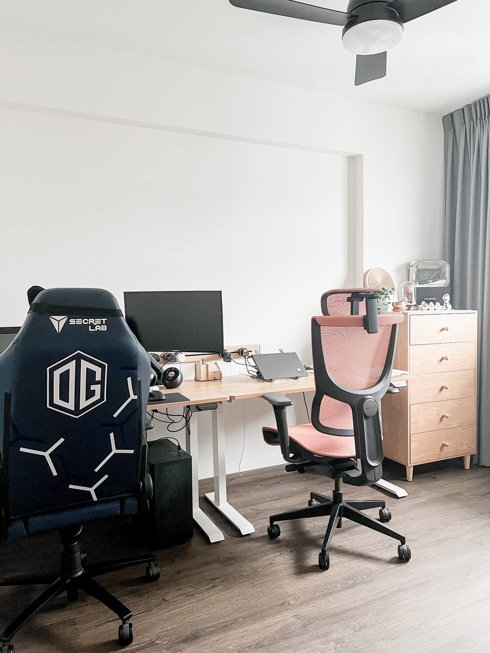Our WFH office - Modern gaming workstation with ergonomic chairs and dual monitors, Sleek black and pink gaming chair with