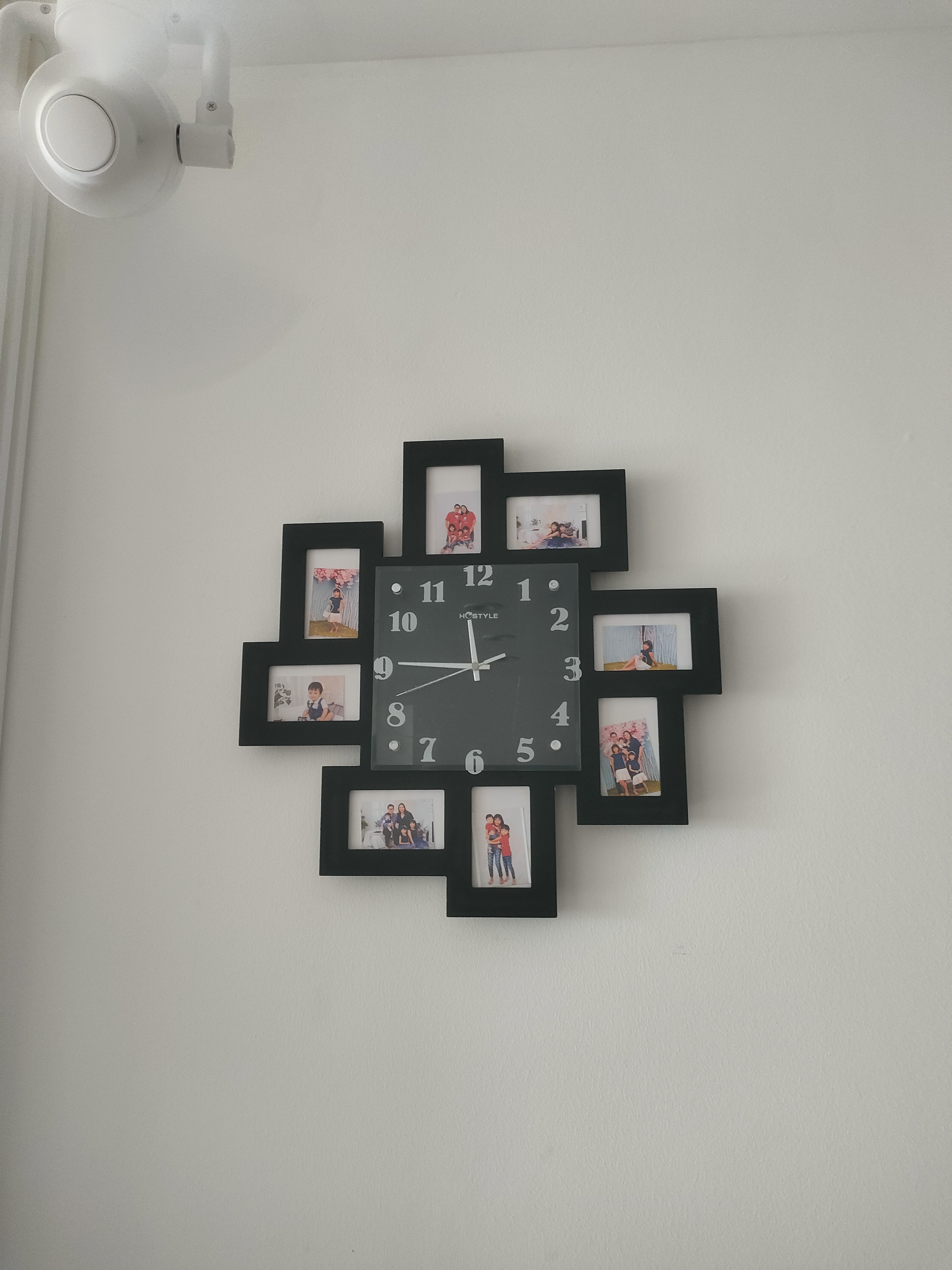 Our guests are greeted by this sight! - Black-framed family photo collage on white wall, Clock with black frame and white