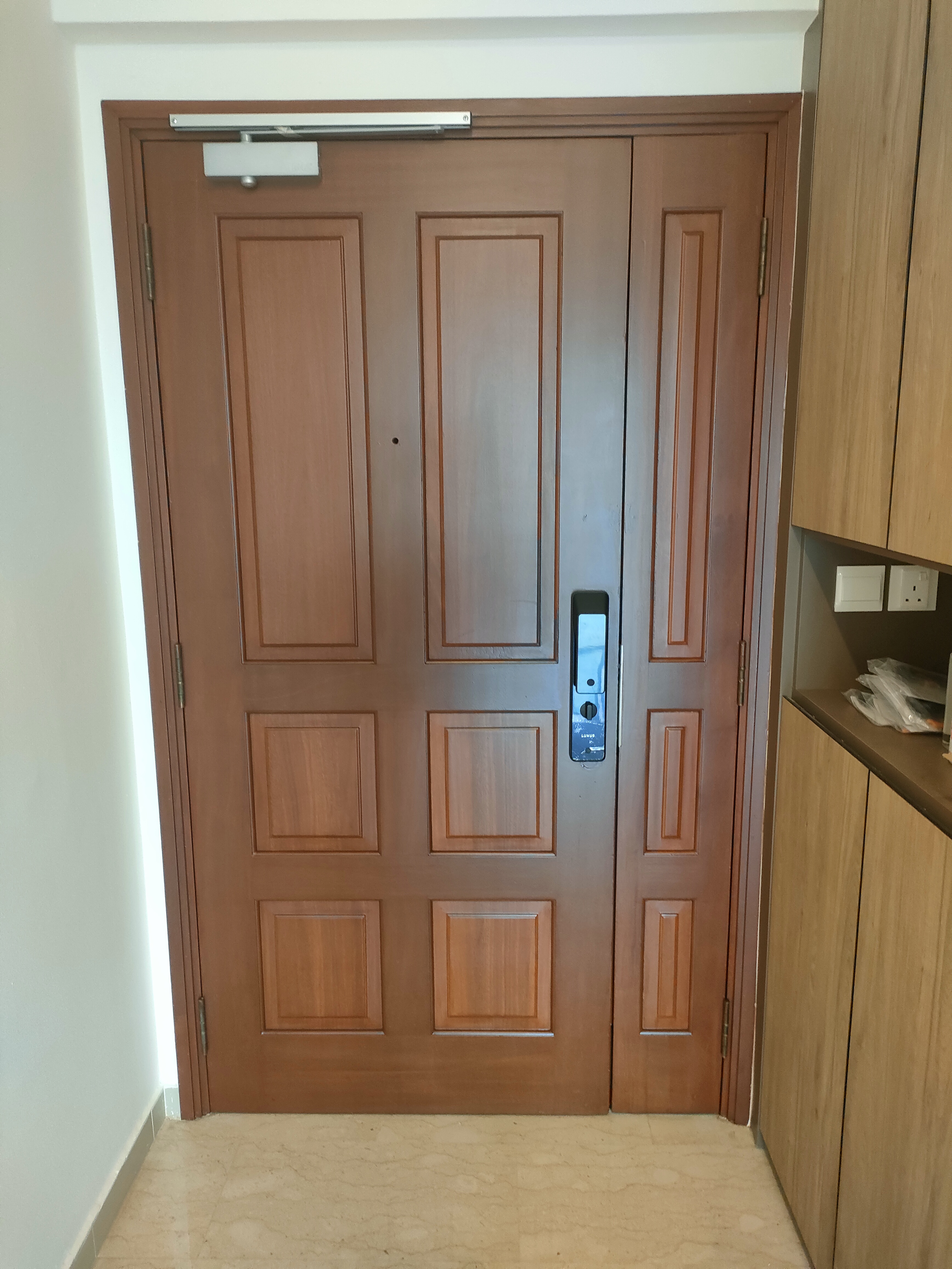 Our guests are greeted by this sight! - Wooden door, brown paneling, recessed lighting, white wall, light fixture, wooden
