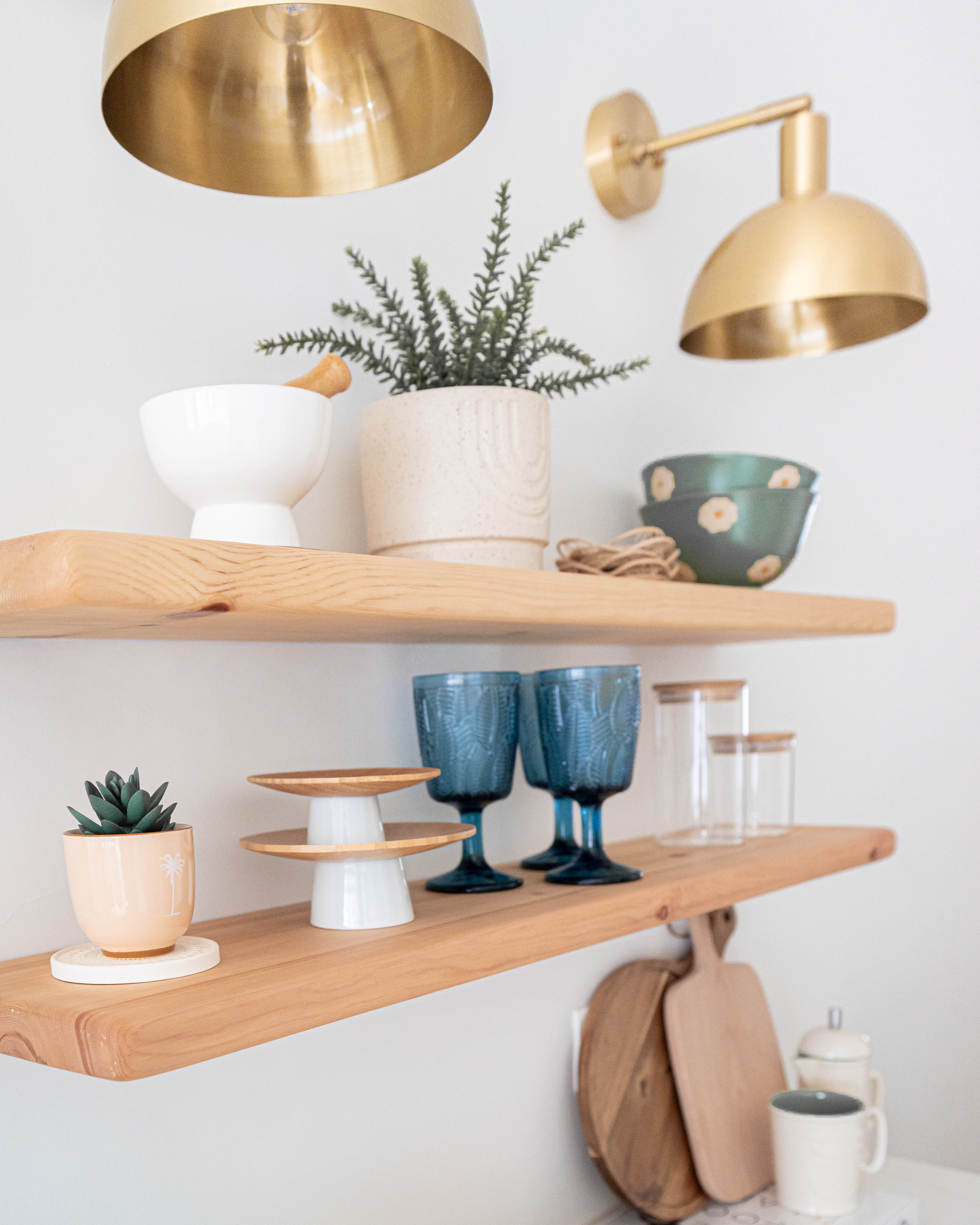 Modern Farmhouse Kitchen & Dining - Golden pendant light, minimalist decor, wooden shelves, potted plant, white coffee mug