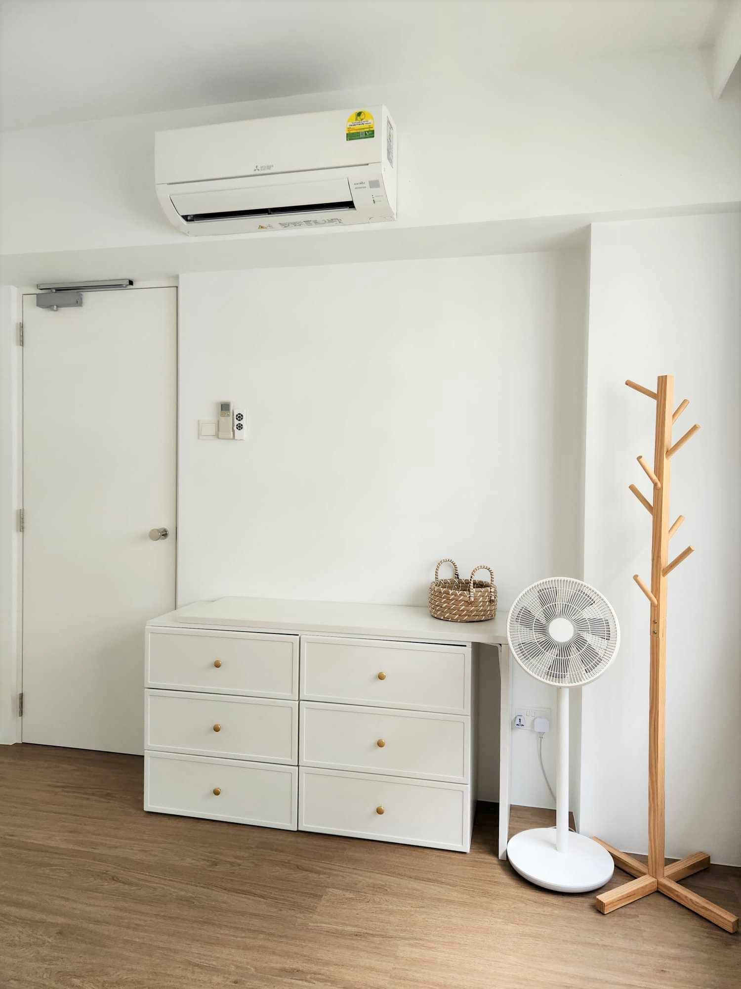 Guest room with inflatable bed for flexibility  - Air conditioner, white wall, minimalist decor, wooden stand, white dresser