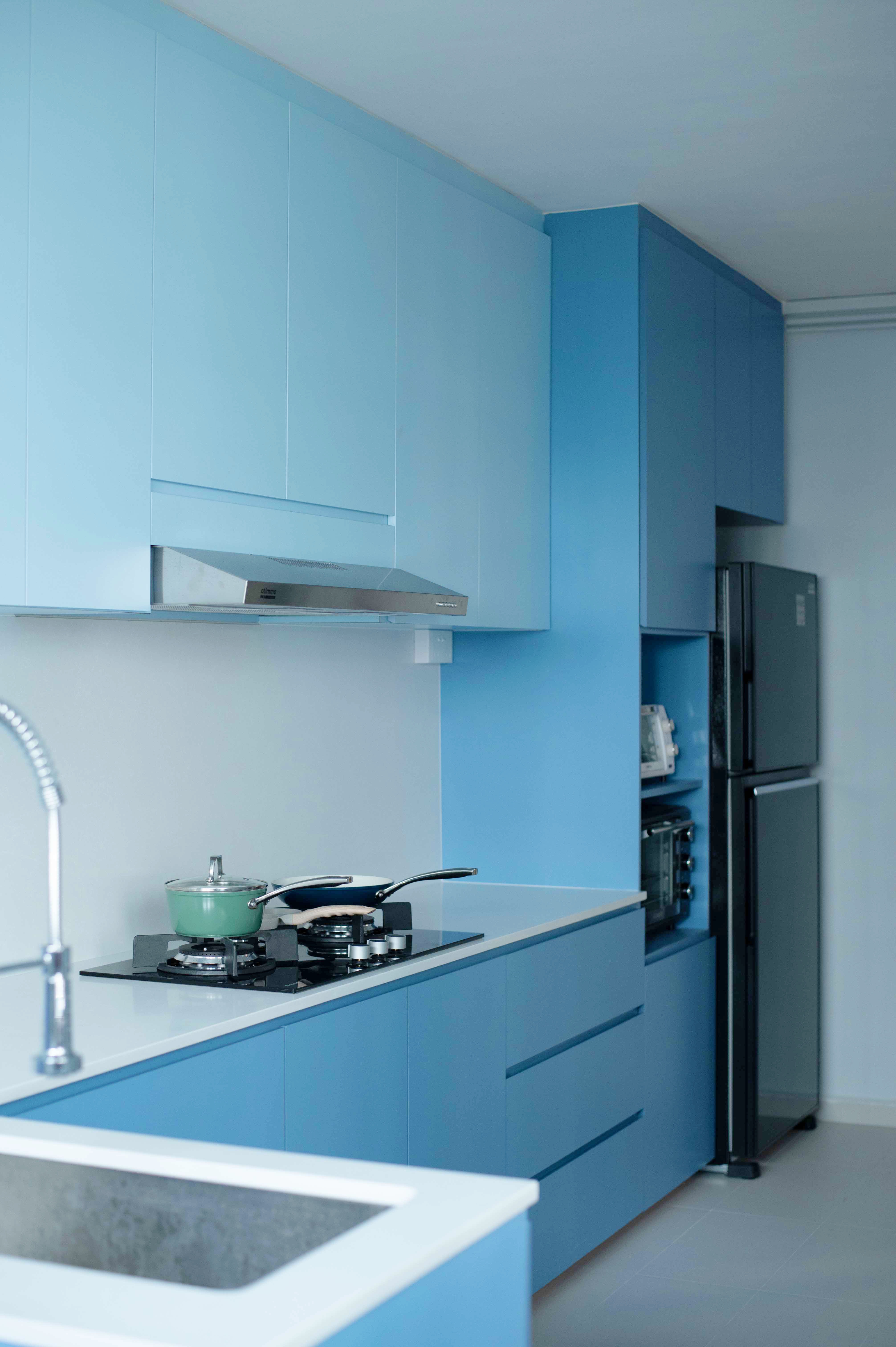 Exploring Blue Tones in a Scandinavian Home - Modern kitchen with blue cabinets, stainless steel range hood, white