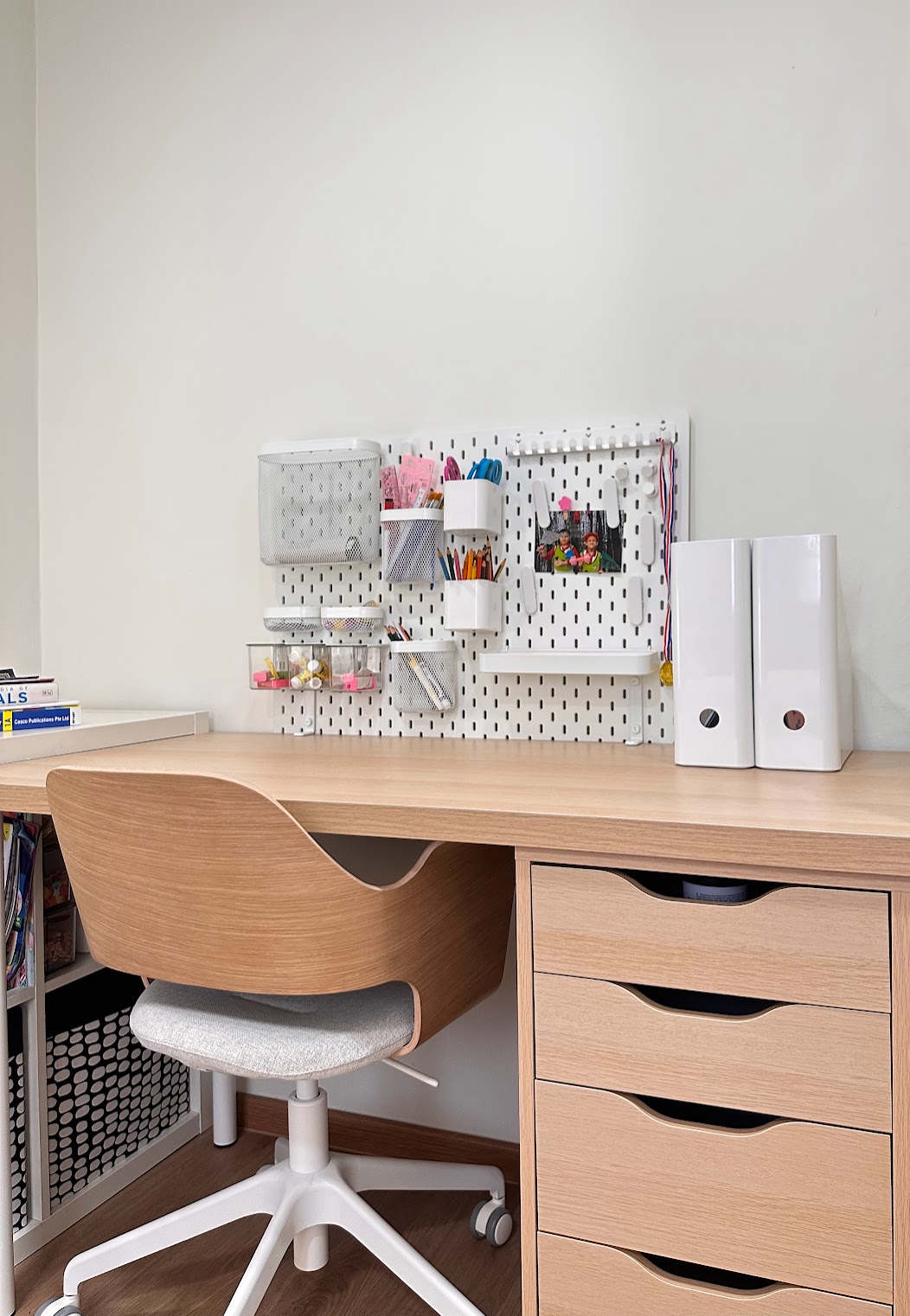 A Super Mario wonderland  - Wooden desk with ergonomic chair, white pegboard wall organizer, small shelves with stationery