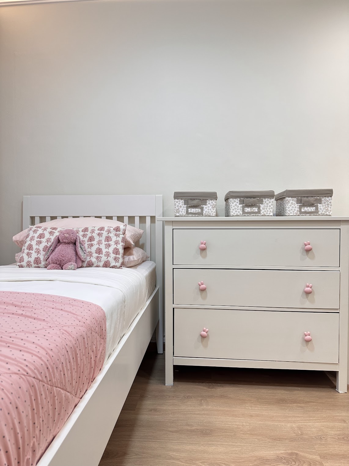 A Super Mario wonderland  - Pink-themed bedroom, white bed frame, floral-patterned pillows, plush bunny toy on bed, pastel