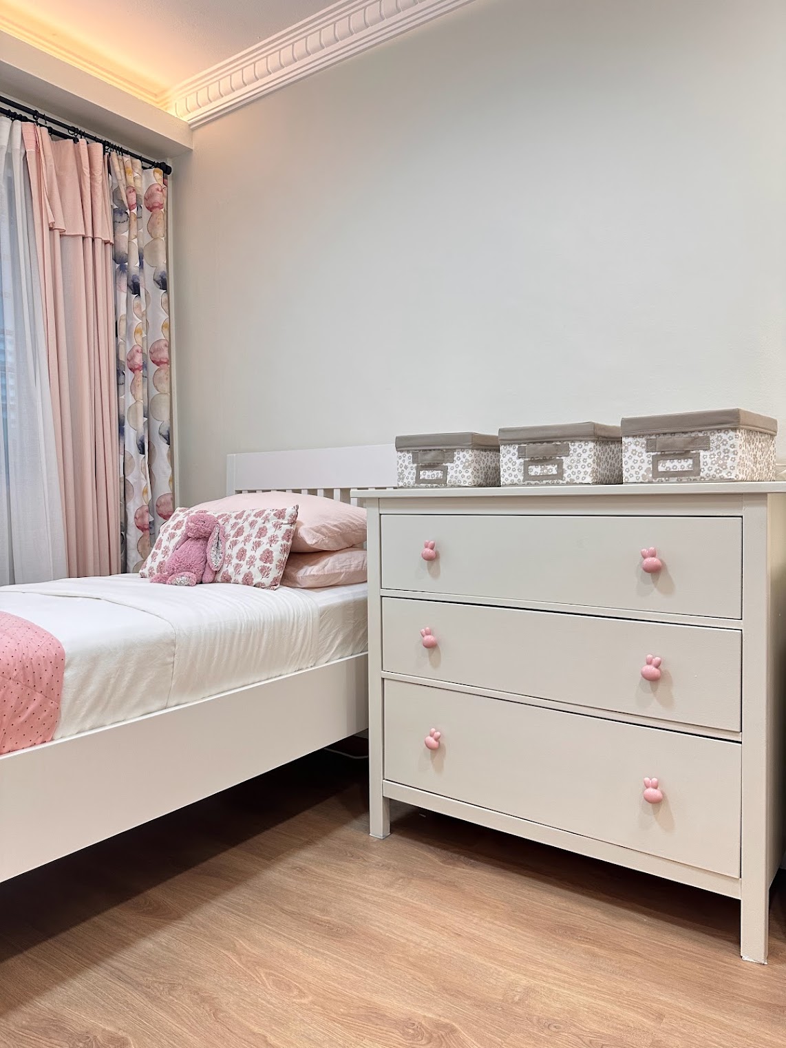 A Super Mario wonderland  - White bed with pink and floral pillows, pink polka dot throw blanket, pastel curtains