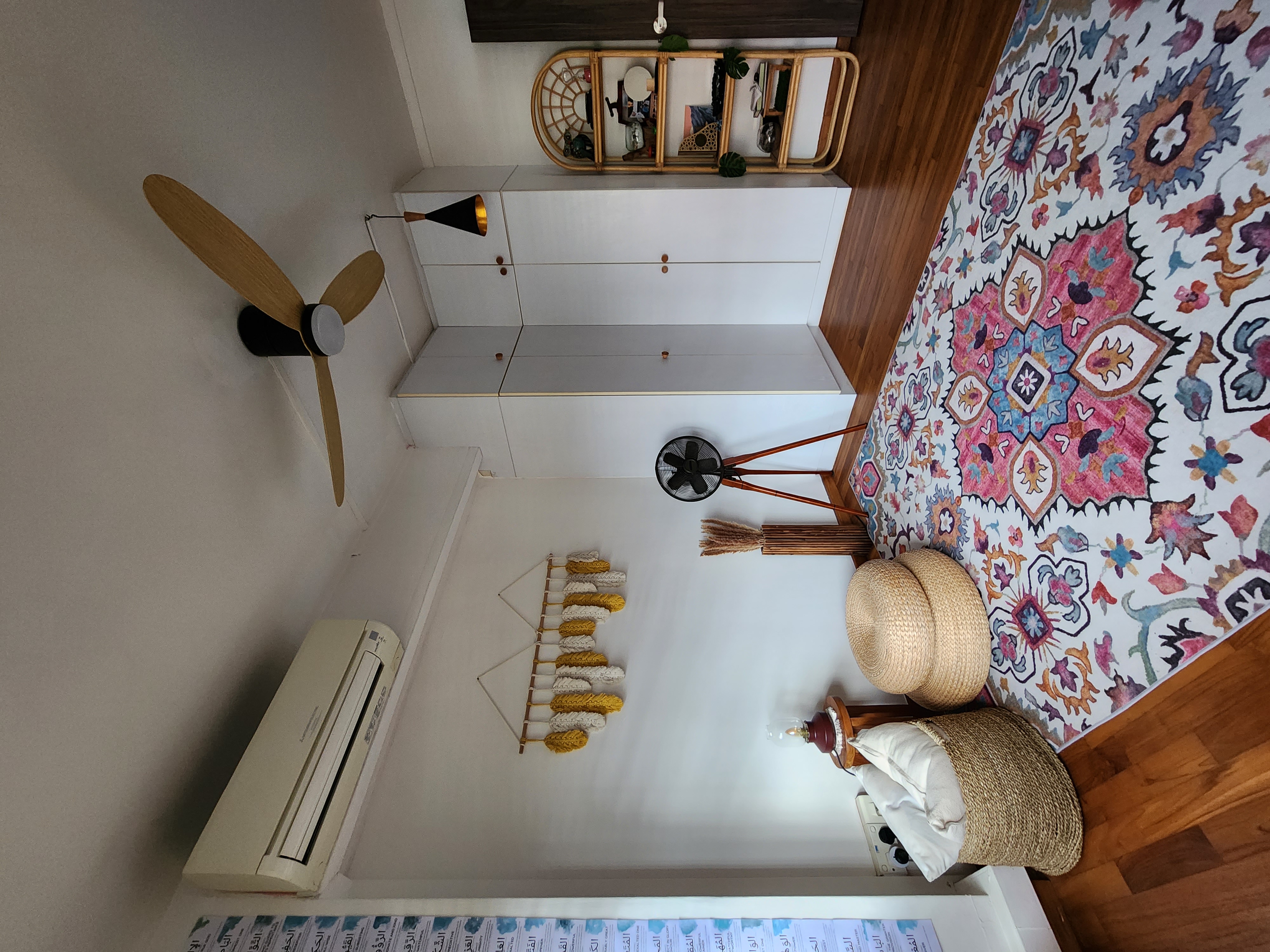 Chillax multi-purpose room - ceiling fan, white cabinet, wooden floor, colorful rug, woven basket, air conditioner