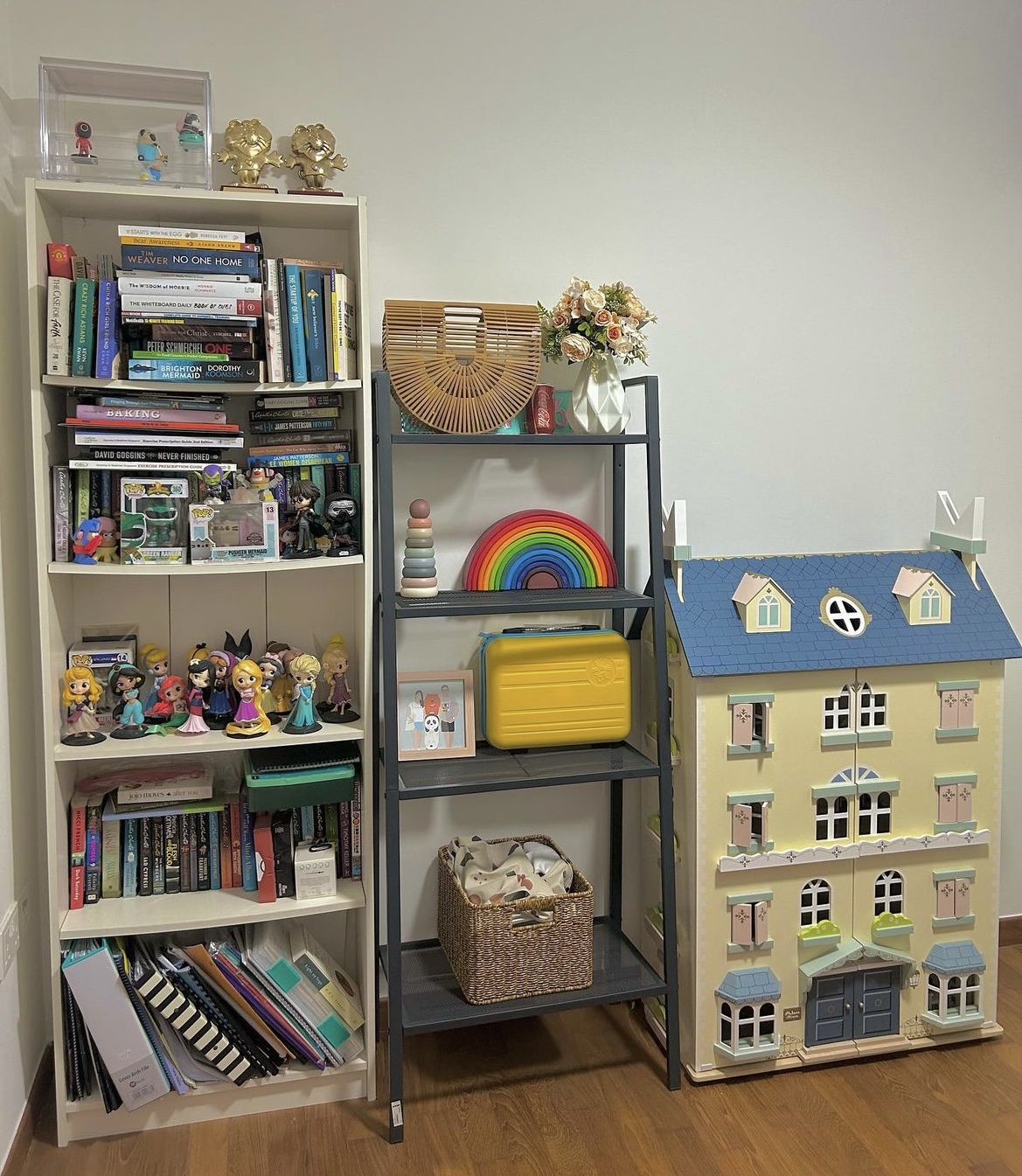 A study in a multi-functional room  - Bookshelf filled with books, figurines, and toys, colorful rainbow decoration, small