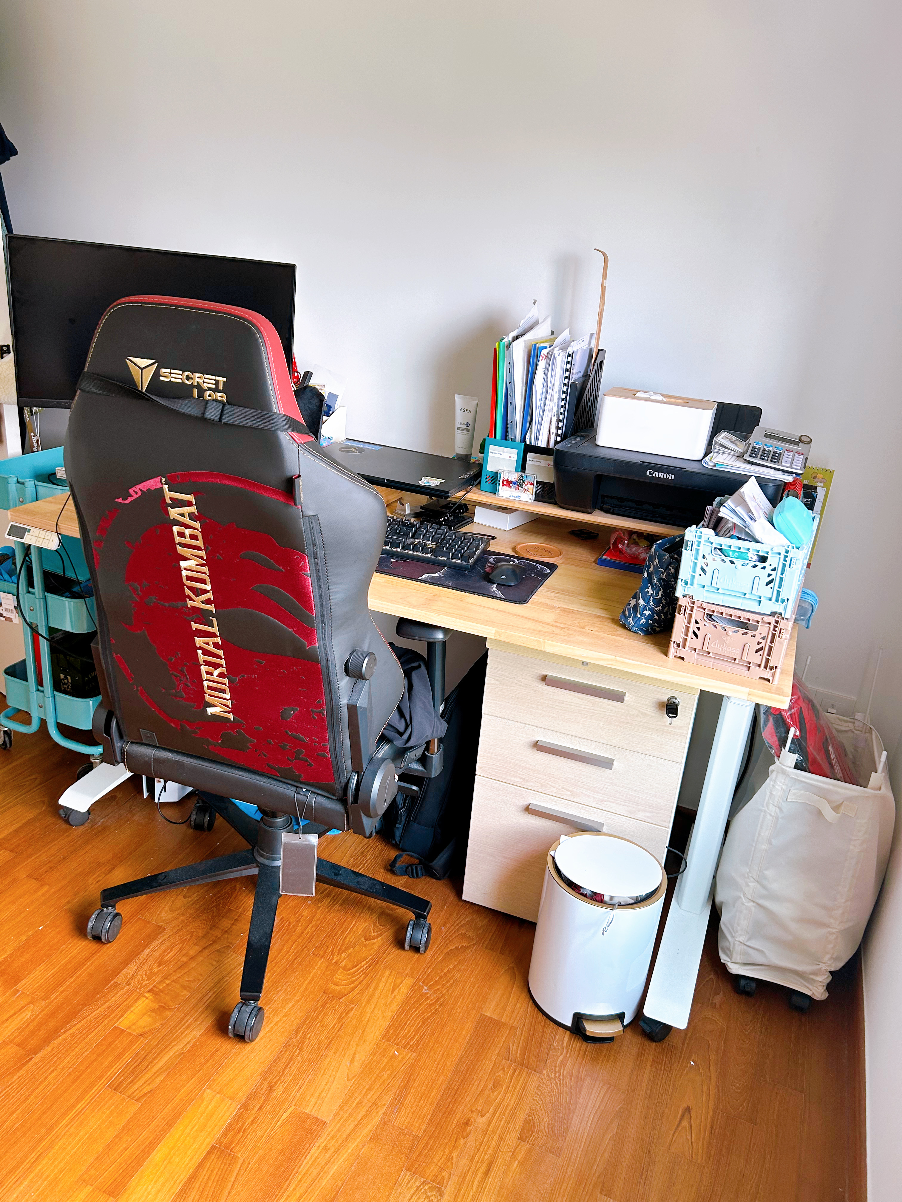 A study in a multi-functional room  - Red gaming chair with "Mortal Kombat" logo, black and red gaming chair, black and red