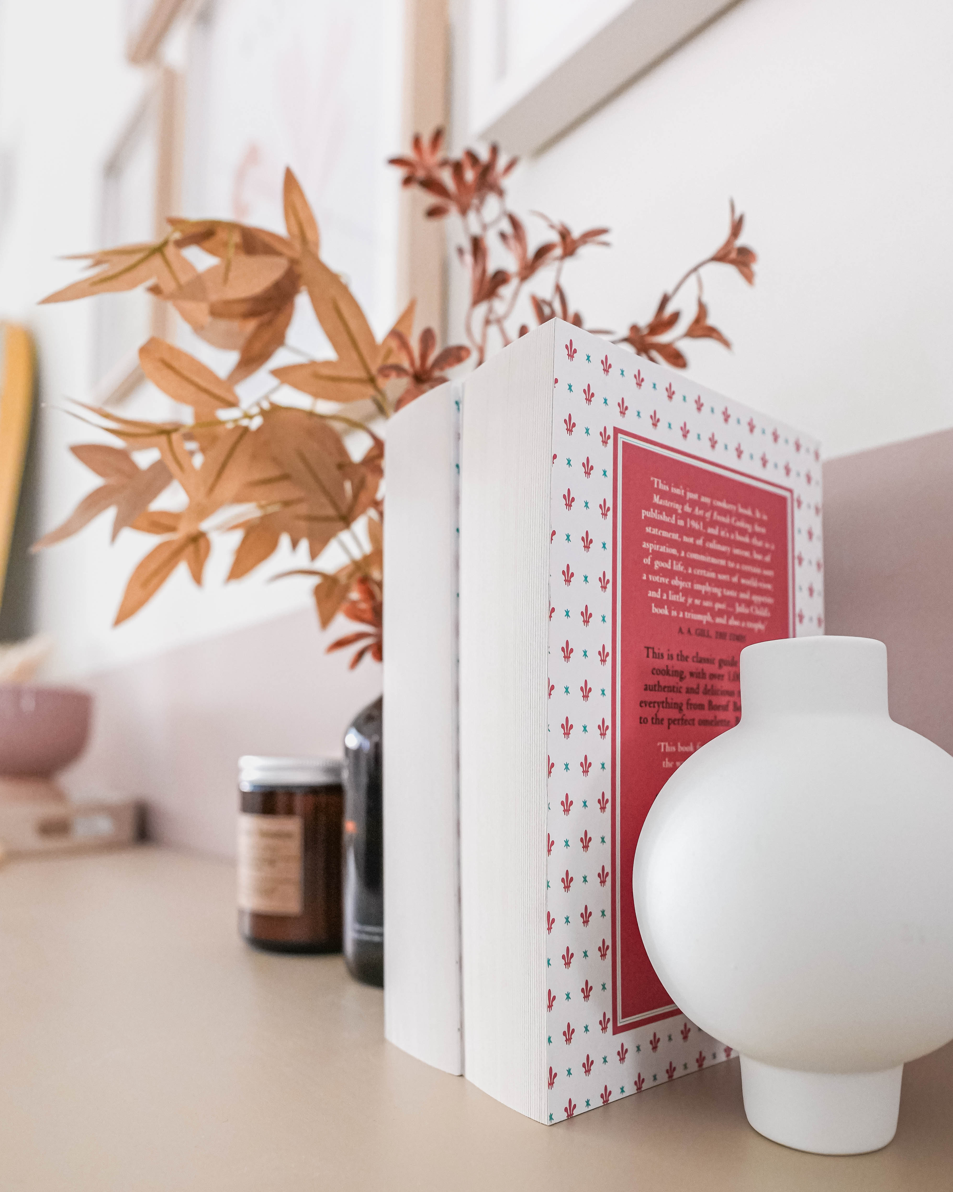 Scandi Living Room, Bedroom & Boho-chic Home Office - Book with red cover and patterned border, white vase on beige surface