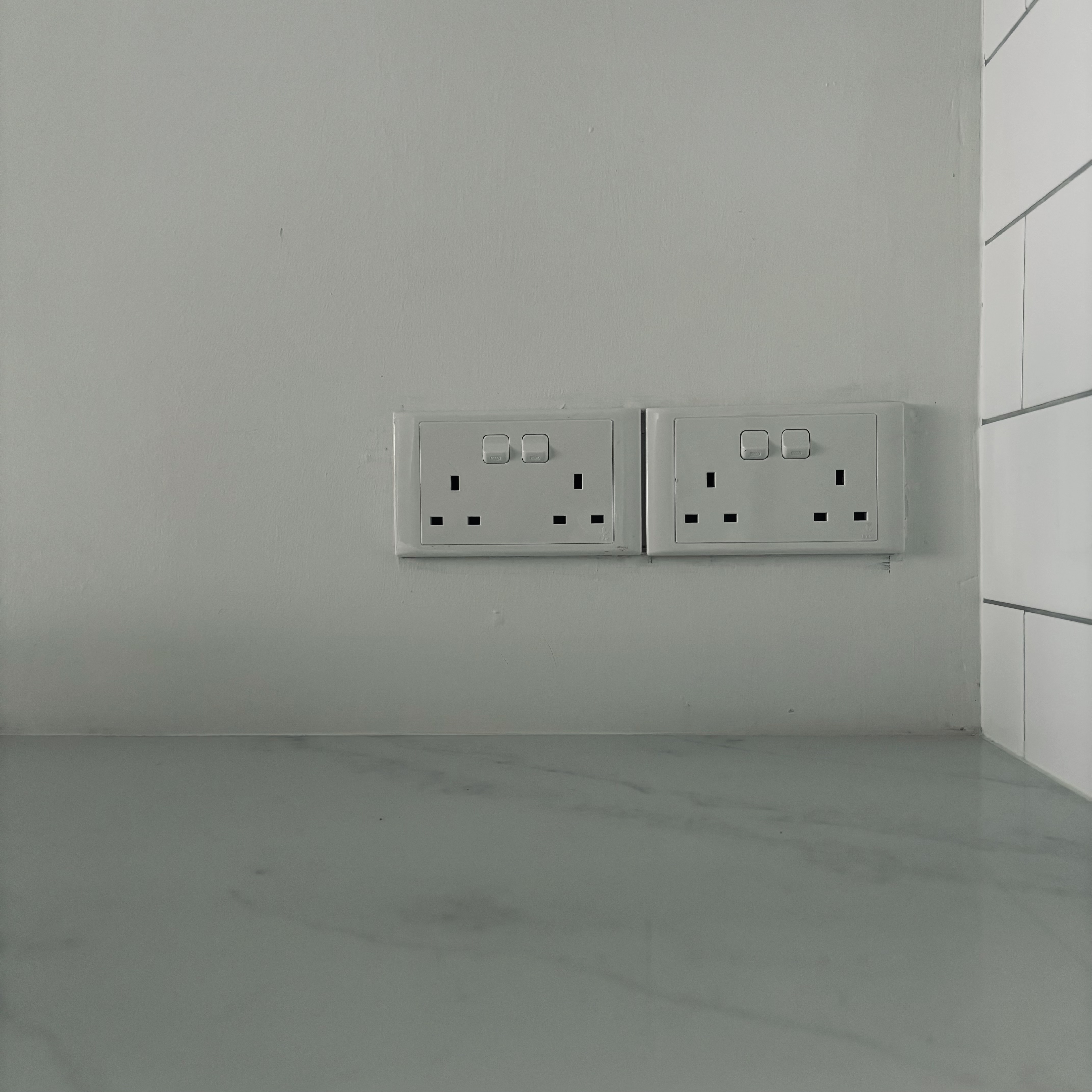 Our blue farmhouse style open concept kitchen!  - White wall with two electrical outlets, gray marble floor, minimalist