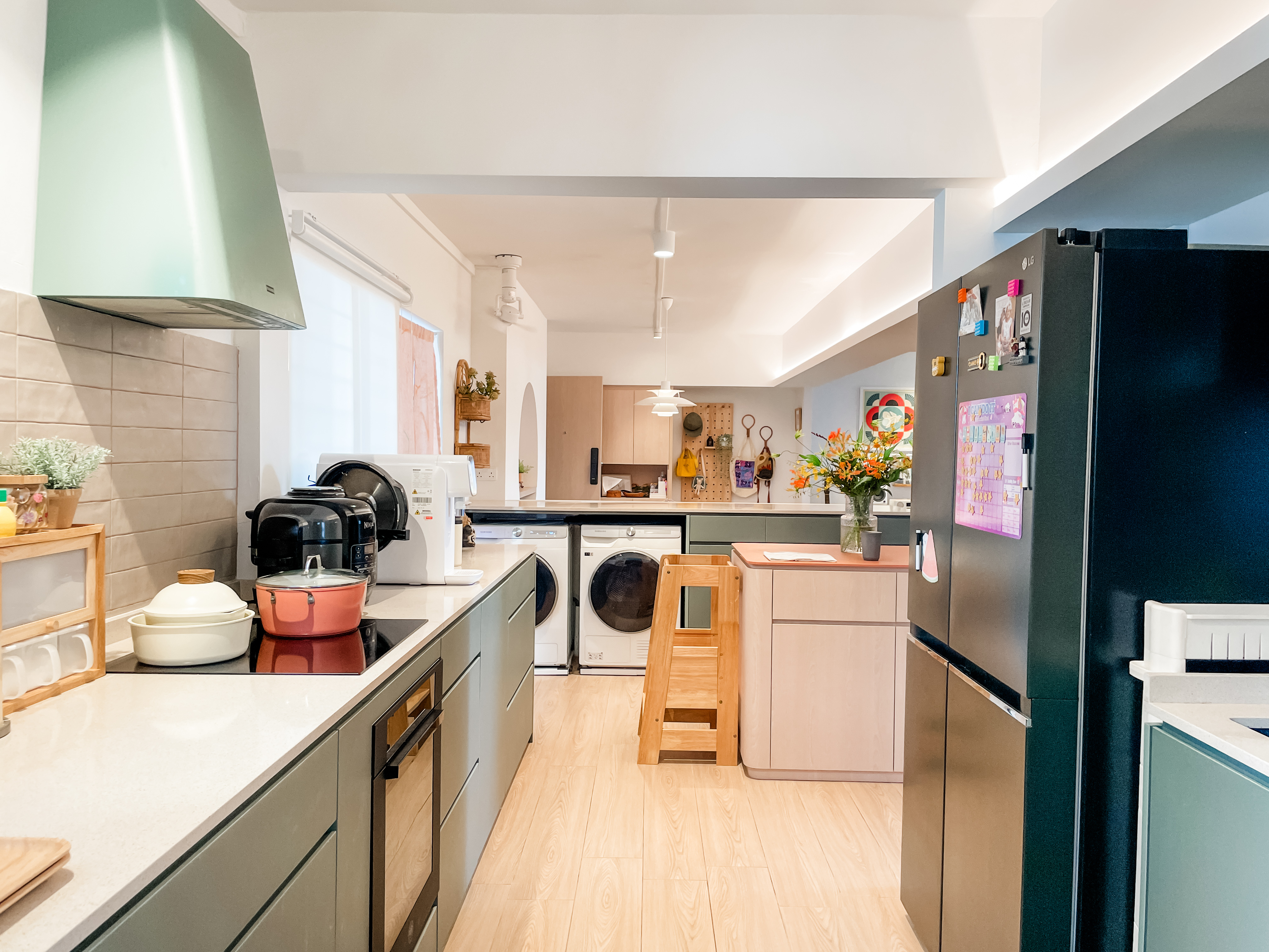 For The Love Of Laundry - Modern kitchen with stainless steel appliances, light wood flooring, green and black refrigerator