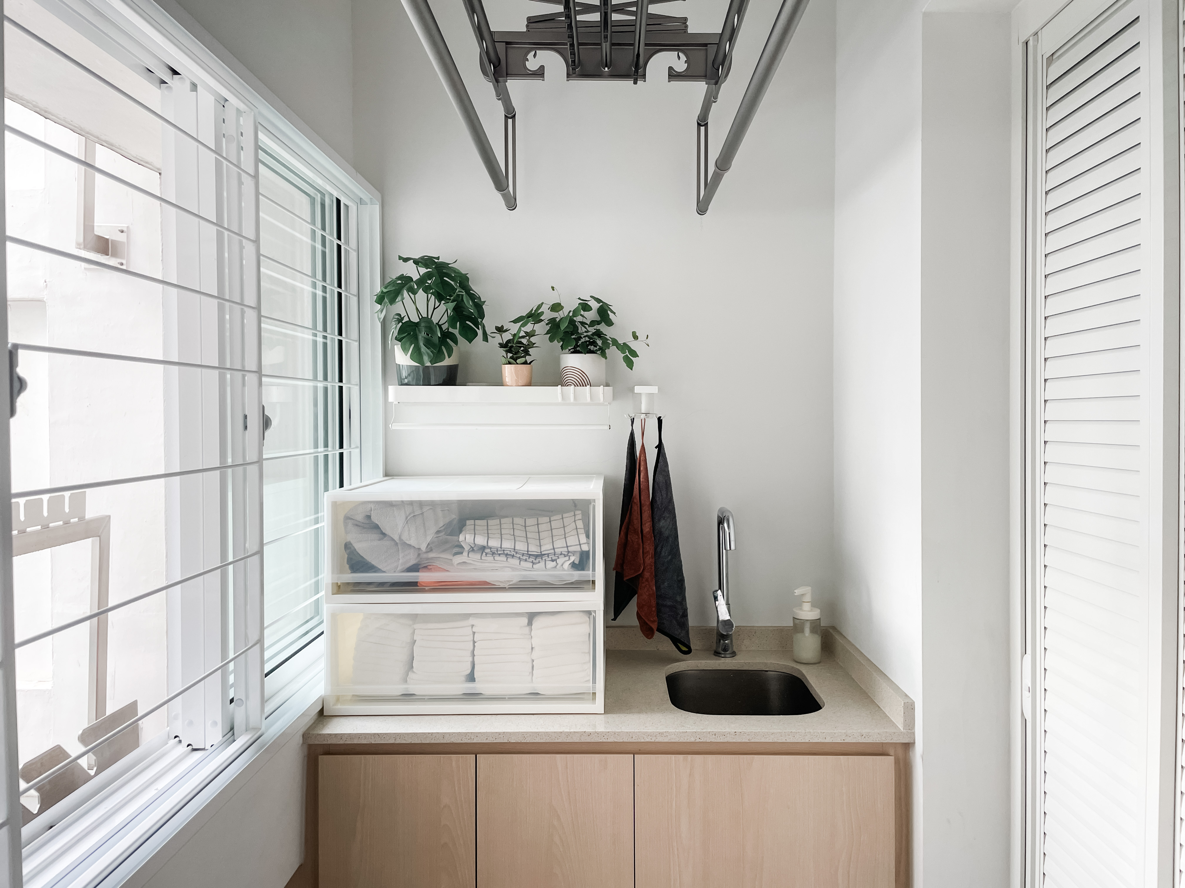 For The Love Of Laundry - white window frame, white blinds, white cabinets, light beige countertop, black sink, wooden