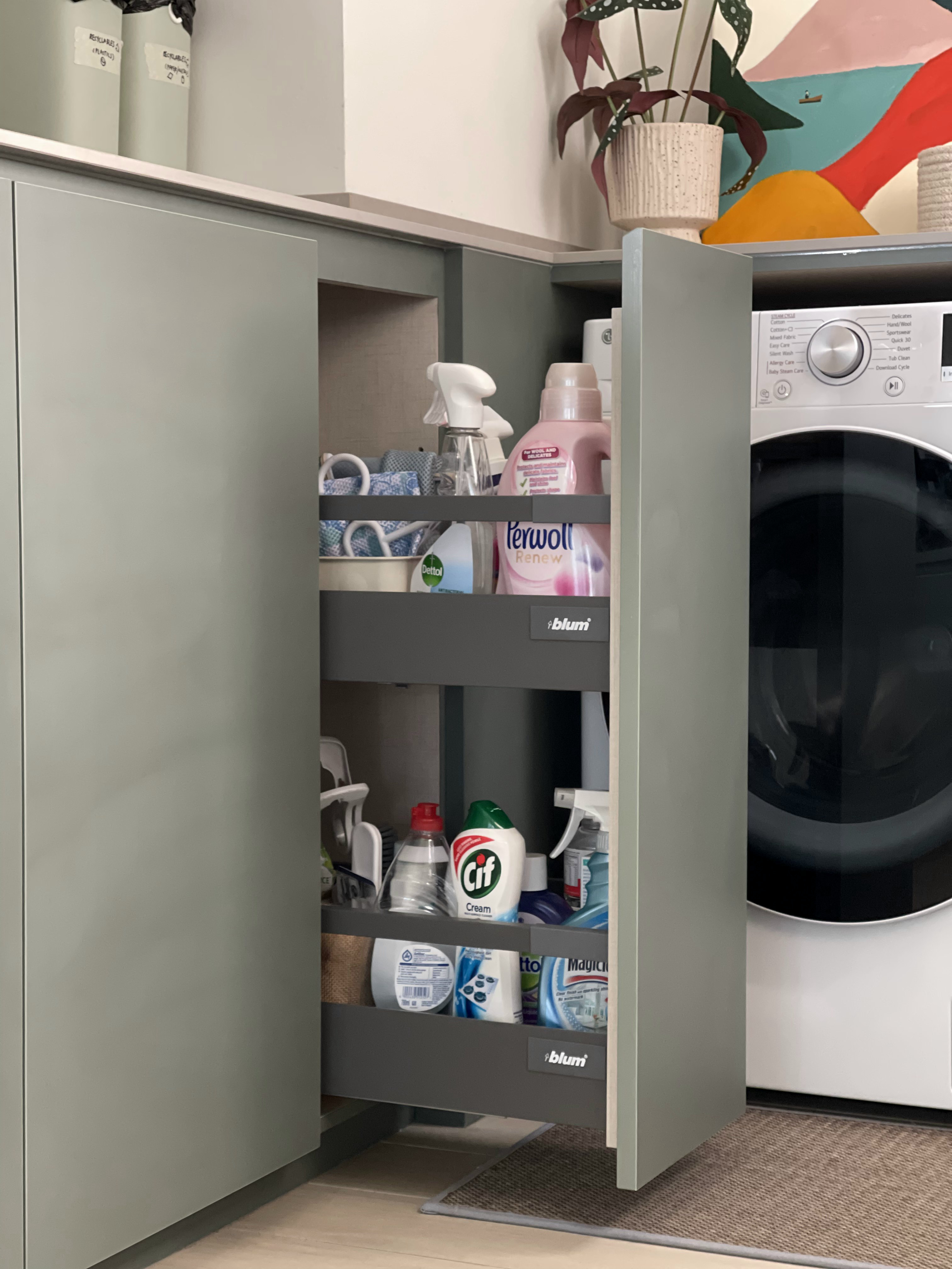 An Open-concept Galley Kitchen + Service Yard - Grey cabinet, laundry detergent, bleach, disinfectant, cleaning supplies