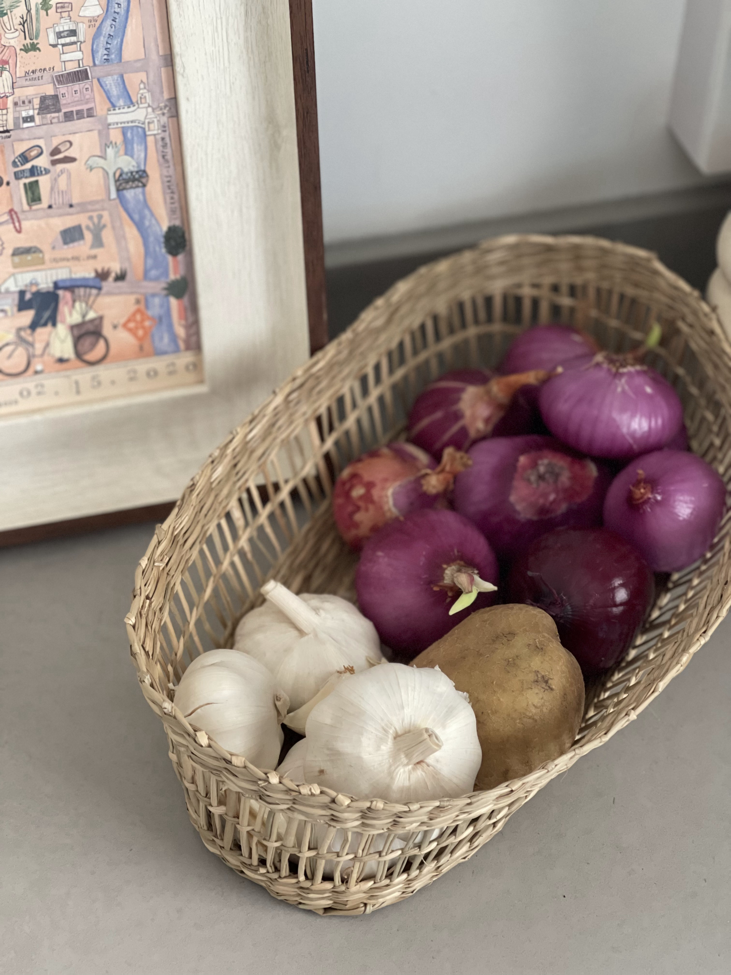 An Open-concept Galley Kitchen + Service Yard - woven basket, fresh produce, onions, garlic, potatoes, rustic charm, natural