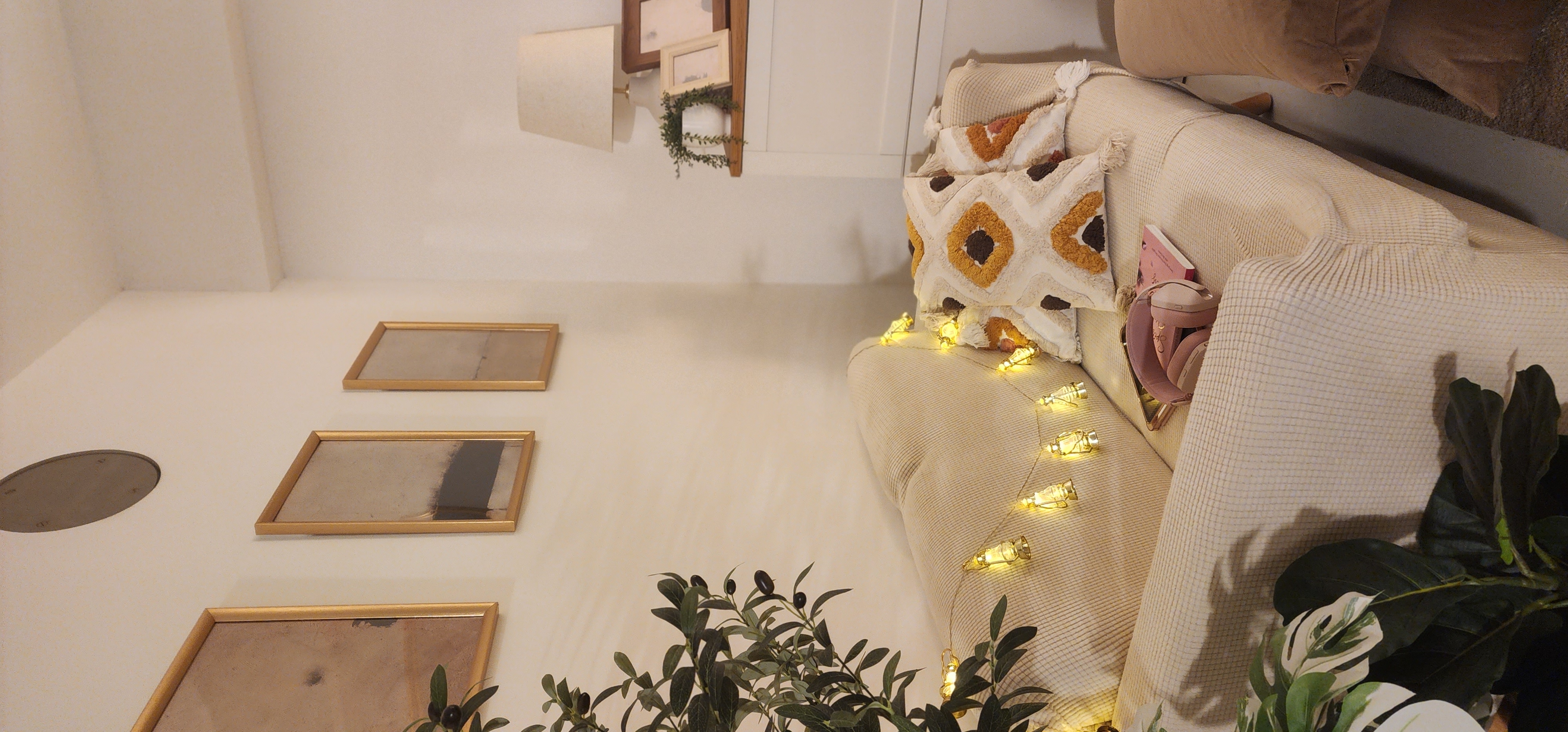 Enjoy your home, you deserve it! - Couch with decorative pillows, beige and brown patterned pillows, string lights, indoor