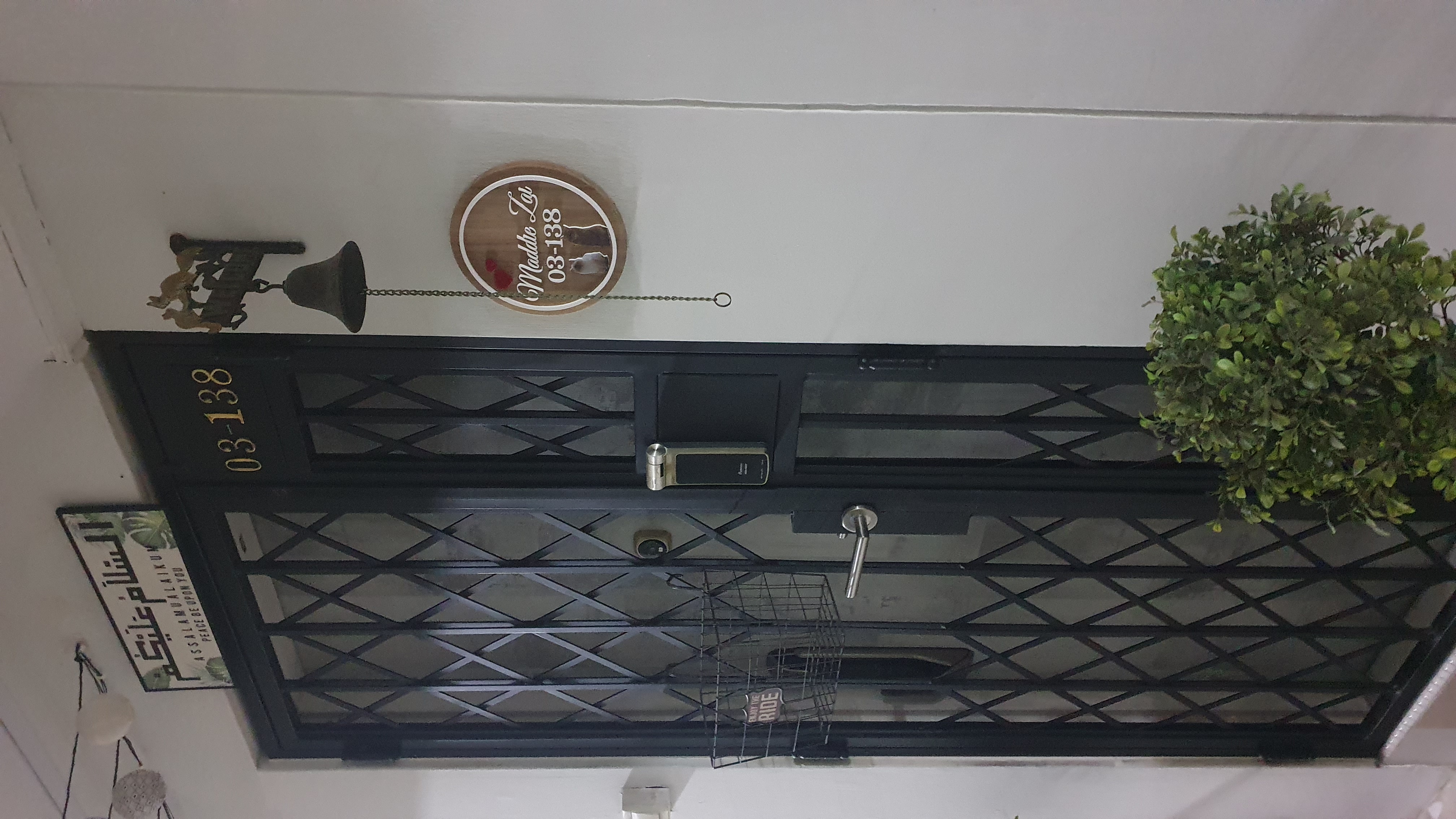 First Impression Matters - Entryway - Black metal gate with diamond pattern, Green potted plant on right side, Wooden sign