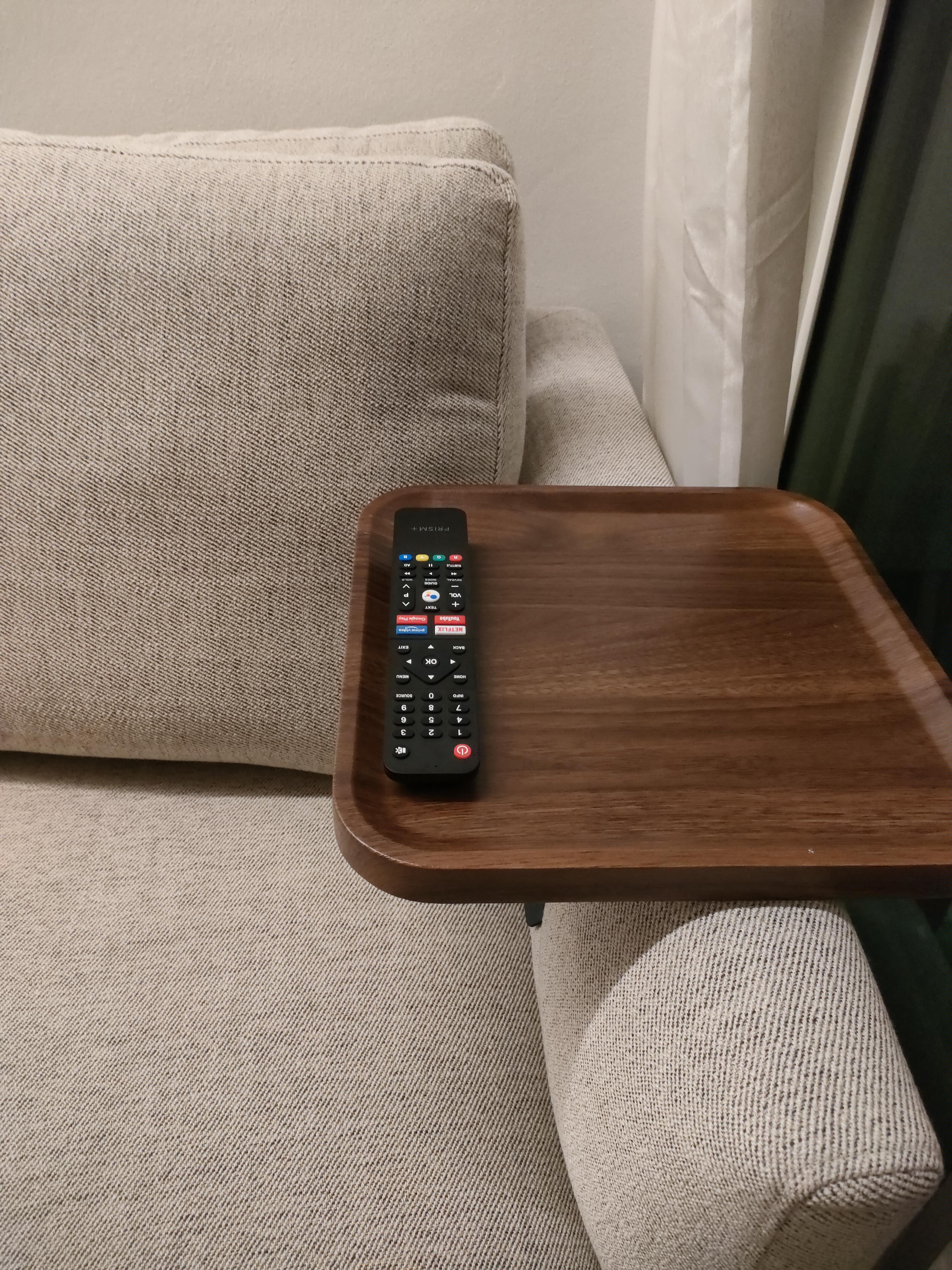 What makes the house our home... - Cream-colored sofa, wooden coffee table, black remote control, beige fabric upholstery
