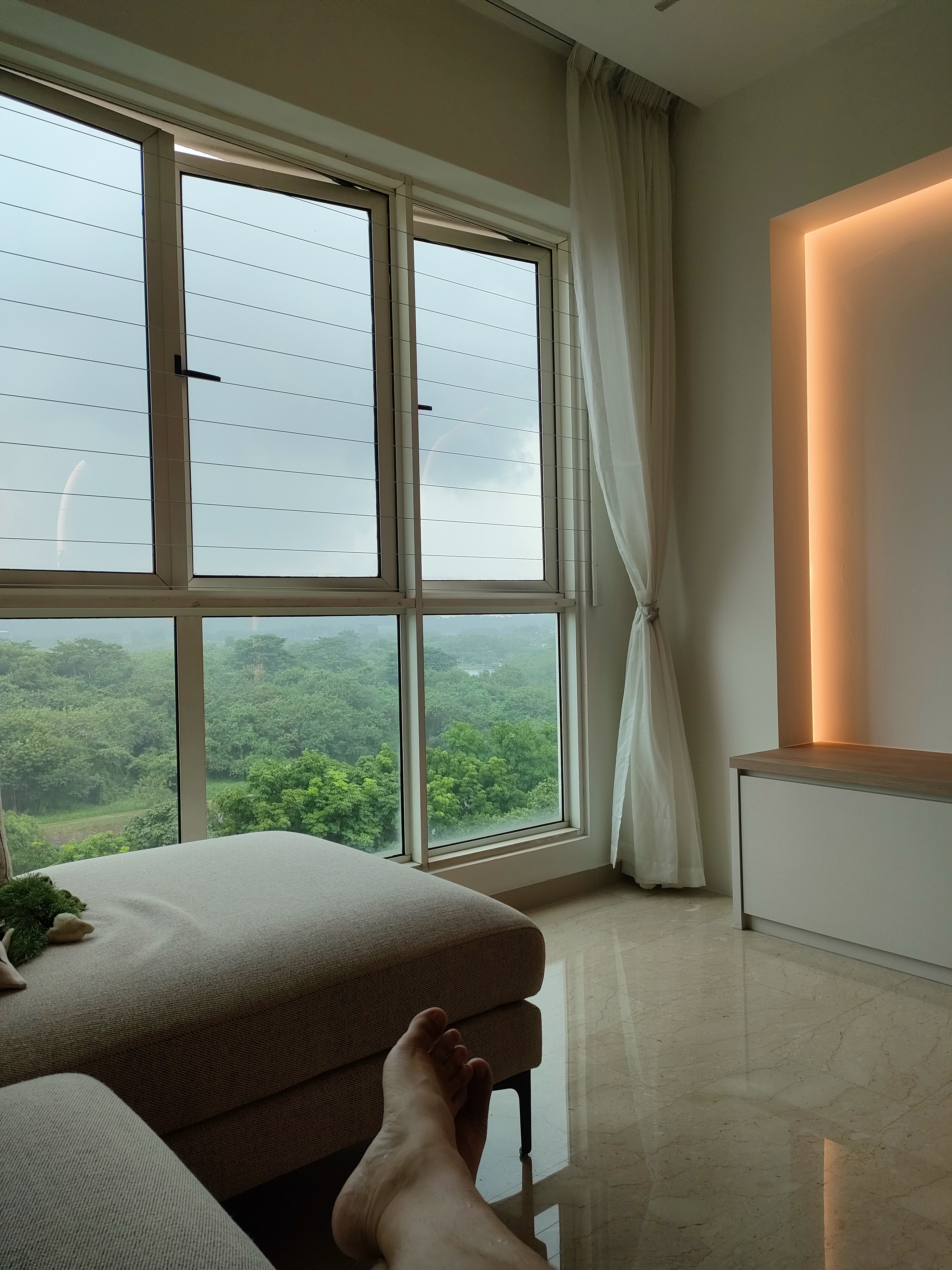 What makes the house our home... - Large windows, natural light, green landscape, indoor view, cozy room, soft lighting