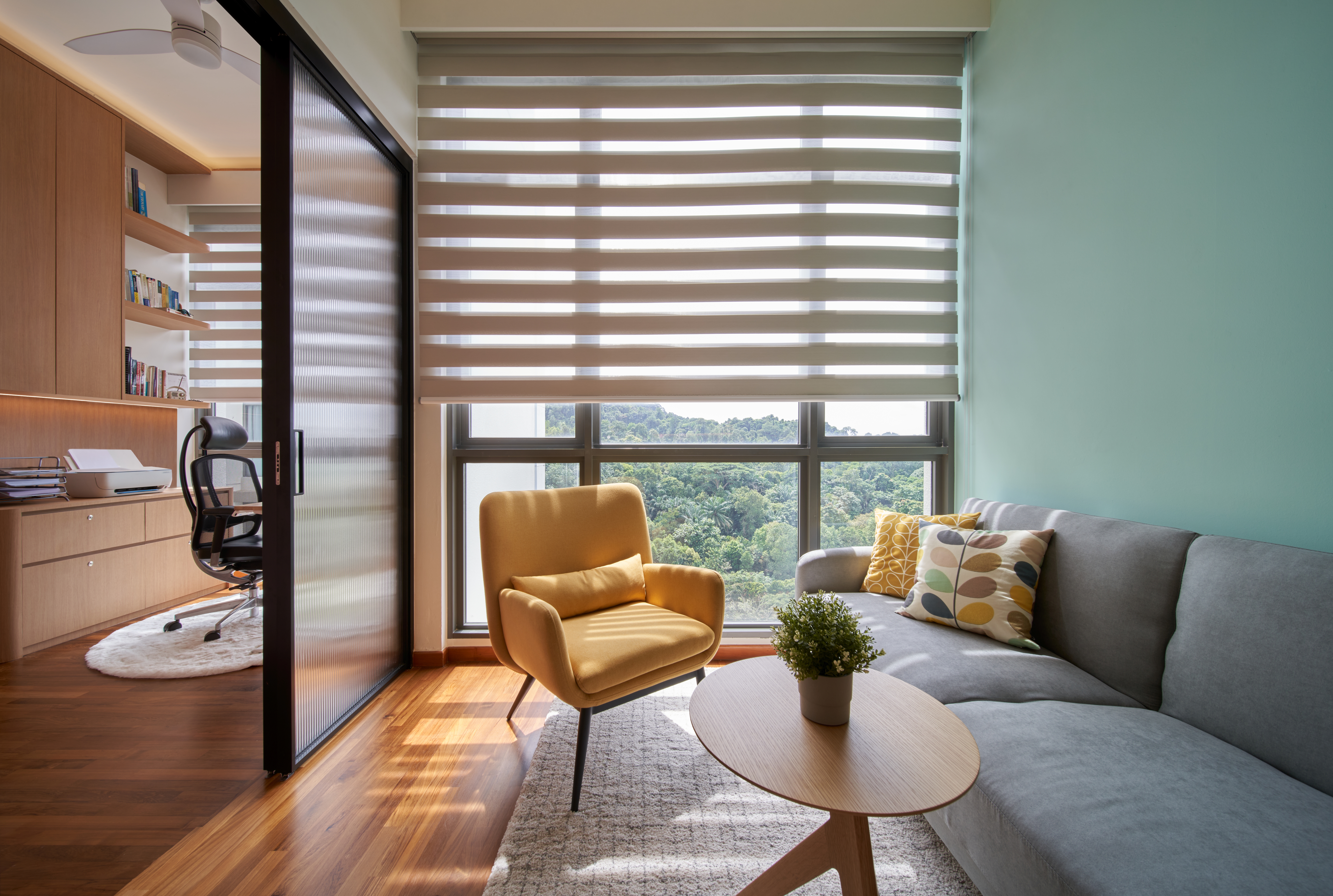 Crafting A Whimsical & Airy Home - Modern living room with large windows, wooden floor, yellow armchair, gray sofa, potted