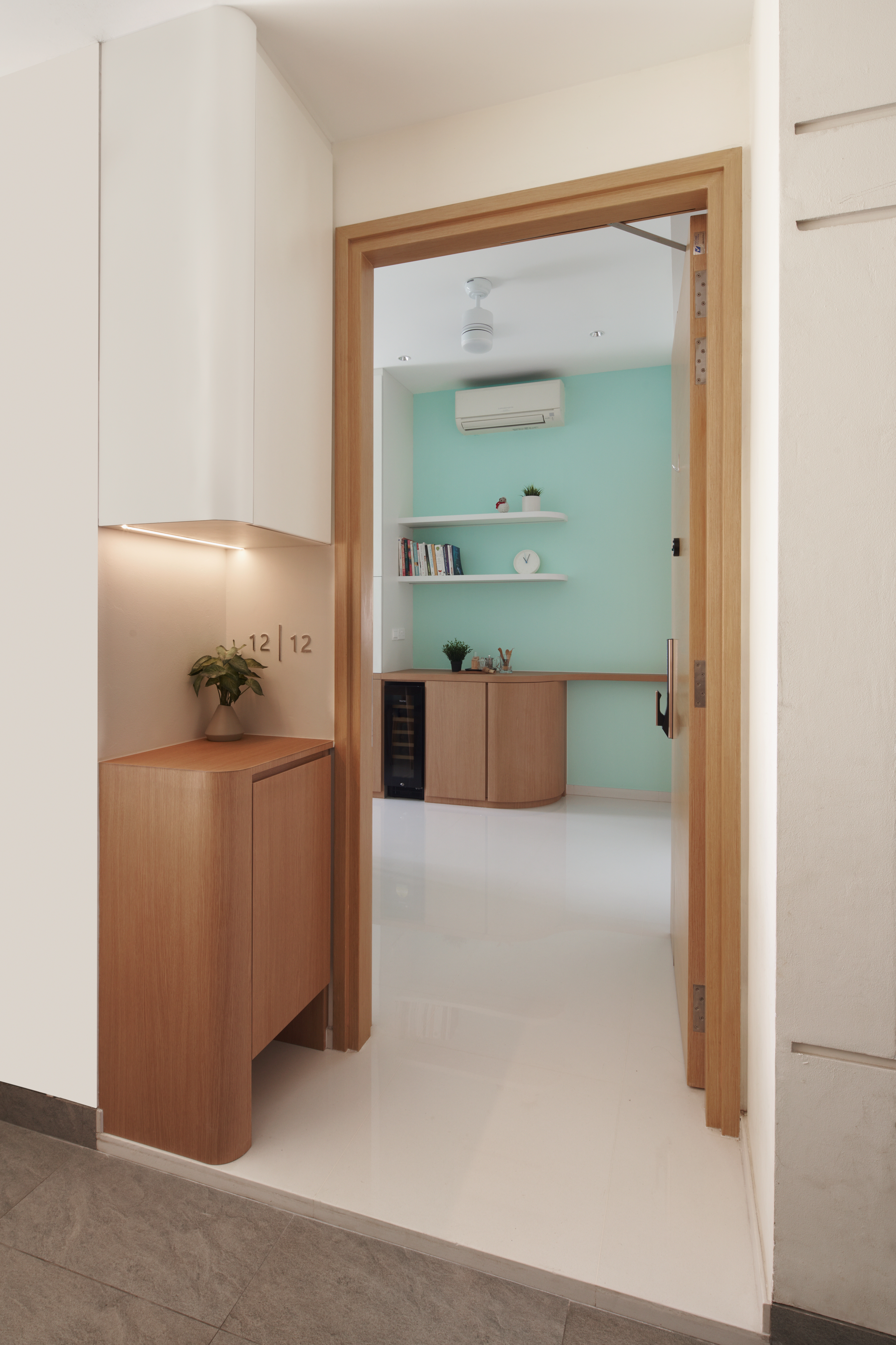 Crafting A Whimsical & Airy Home - Modern minimalist interior, wooden cabinets, light green wall, white ceiling, small potted