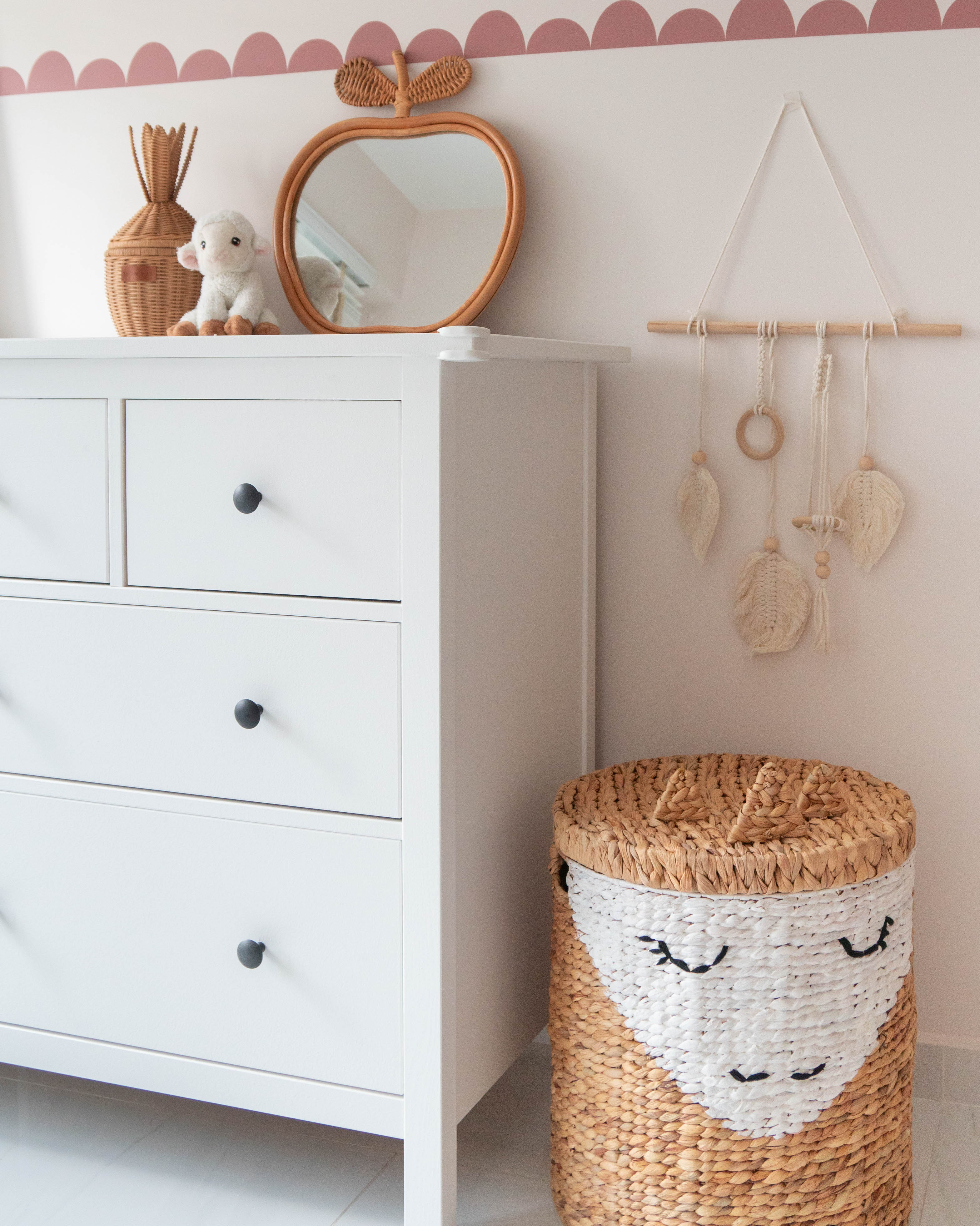 Gender Neutral Kids' Playroom + Girly Dress-Up Room - White dresser with black knobs, woven basket with smiling face, pink