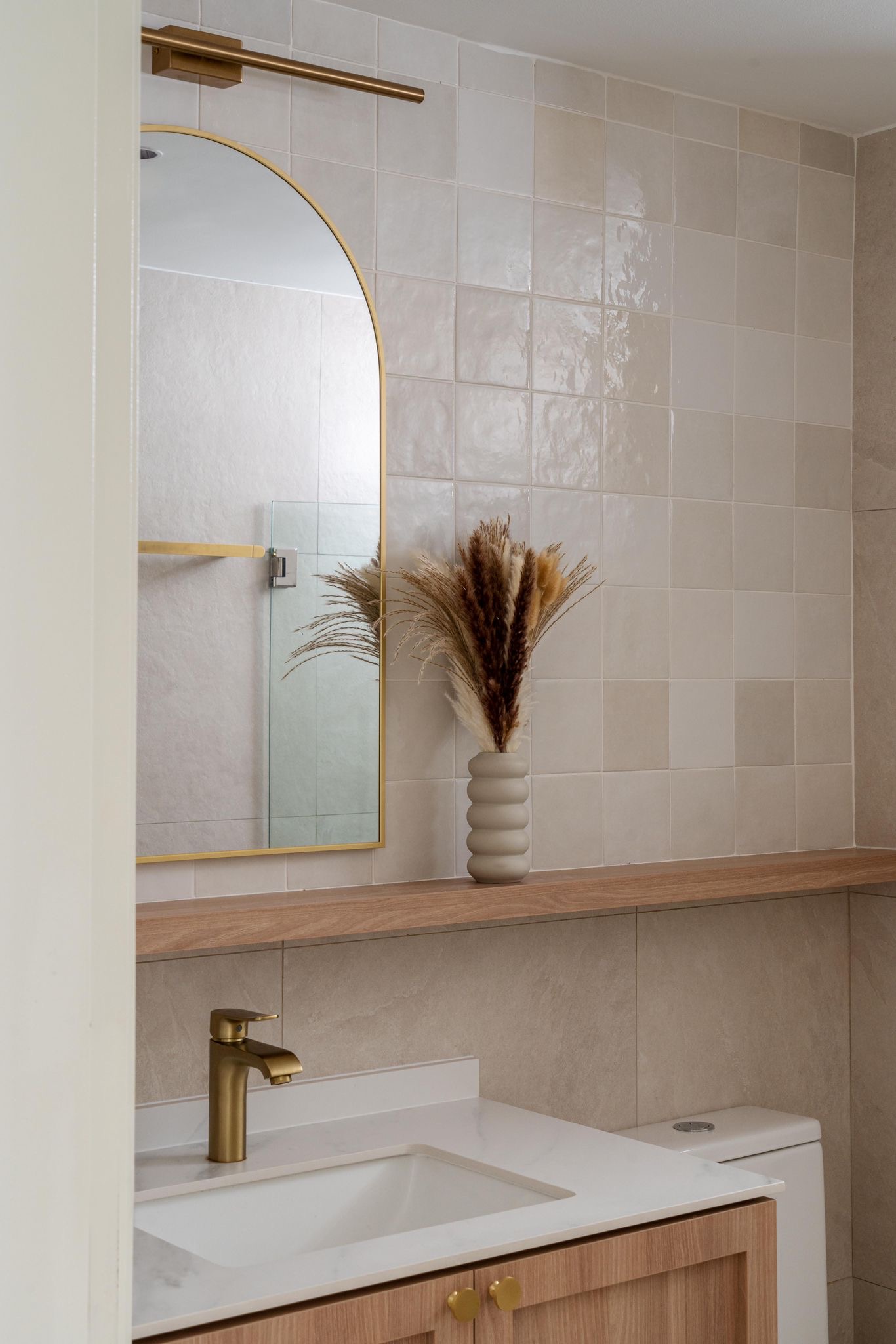Keeping our bathroom minimal  - Gold-framed mirror, beige tiled wall, wooden vanity, gold faucet, white sink, beige tiles