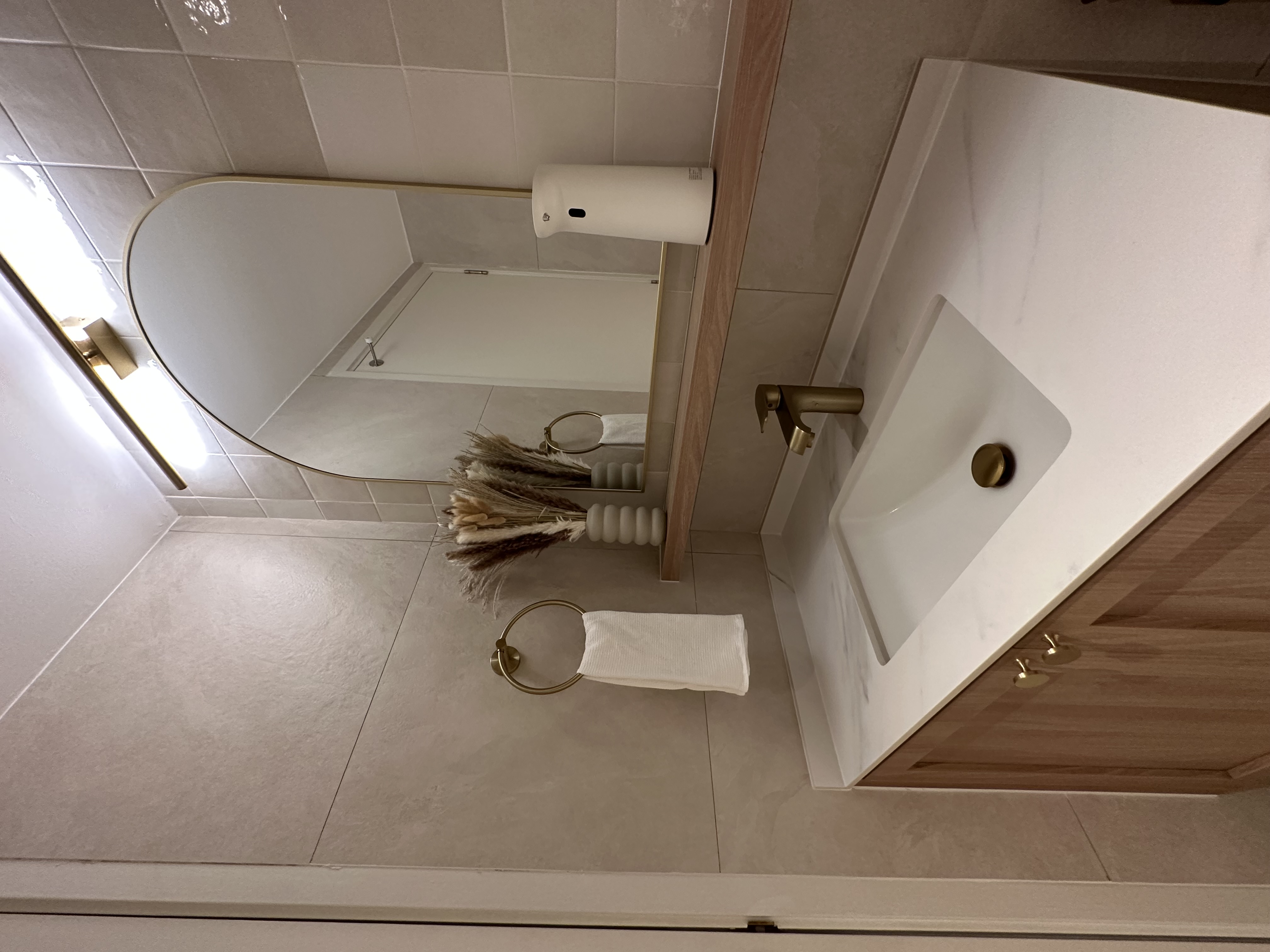 Keeping our bathroom minimal  - Large mirror, bathroom, vanity, white sink, gold fixtures, tiled floor, wooden cabinet, gold