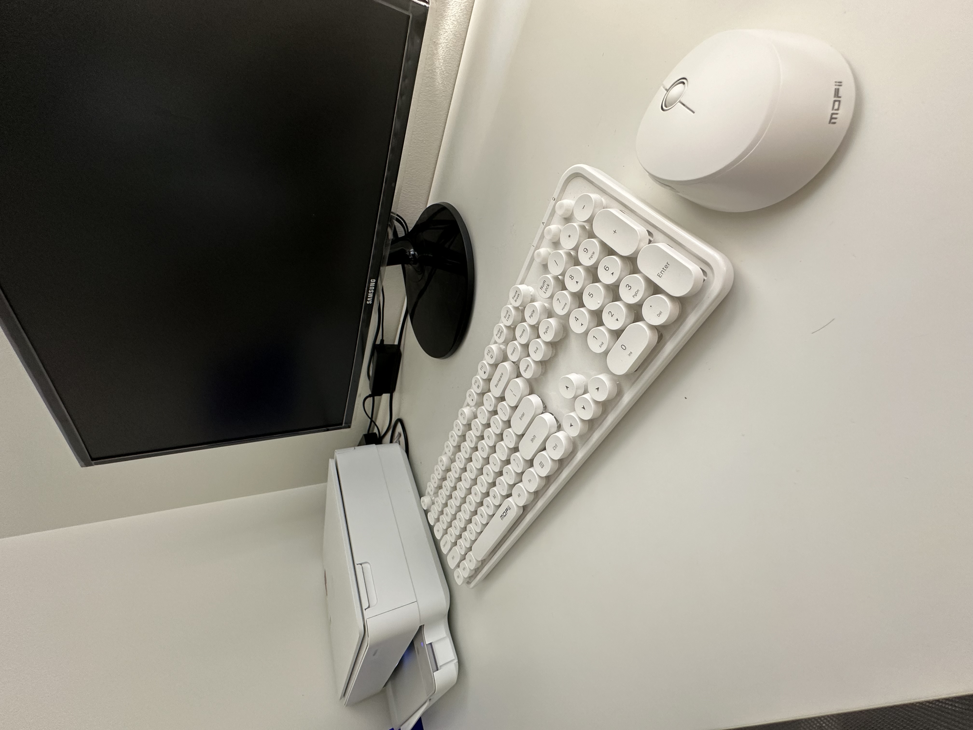 Our tiny home office + crafting room  - Sleek white keyboard with ergonomic design, Modern computer setup with minimalistic