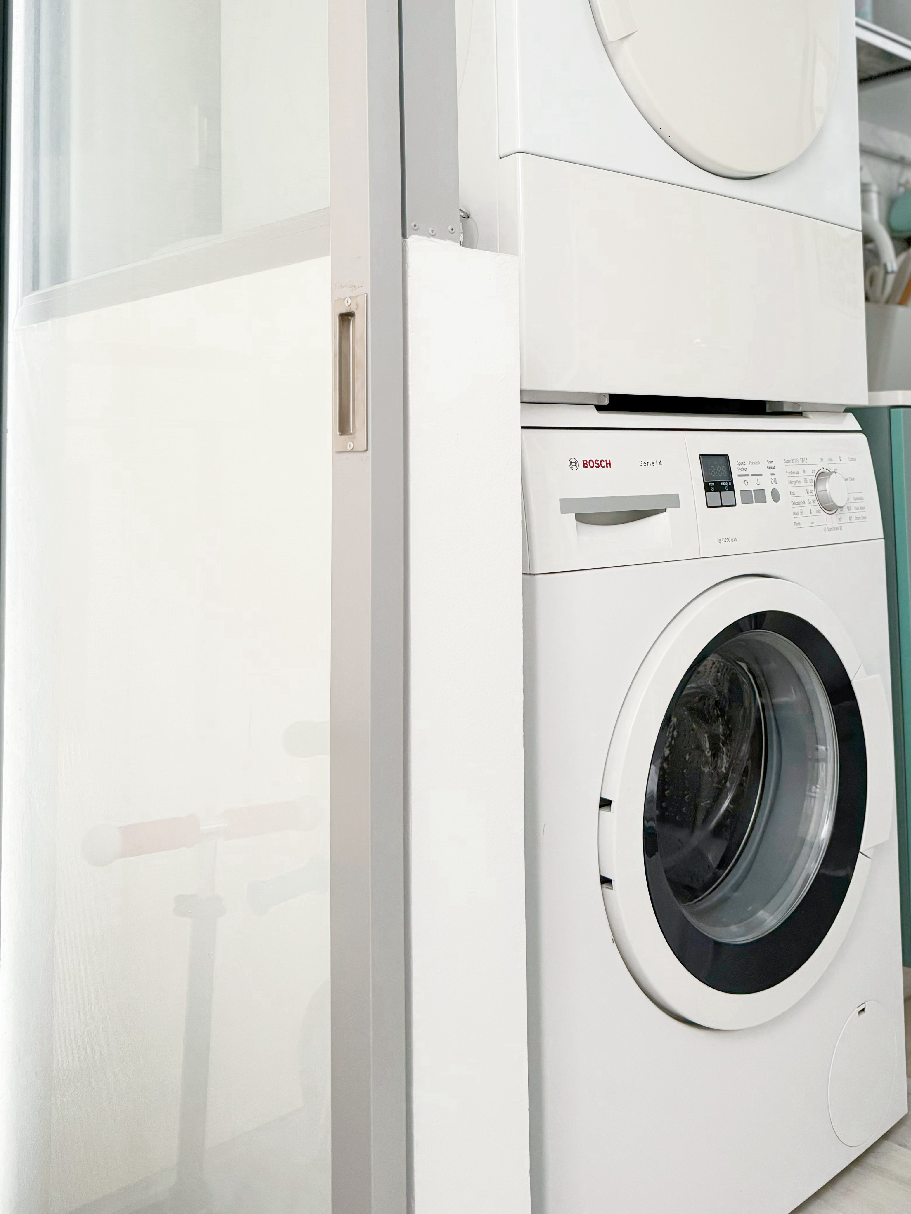 A Small but Efficient Laundry Area - White Bosch washing machine, modern design, control panel, digital display