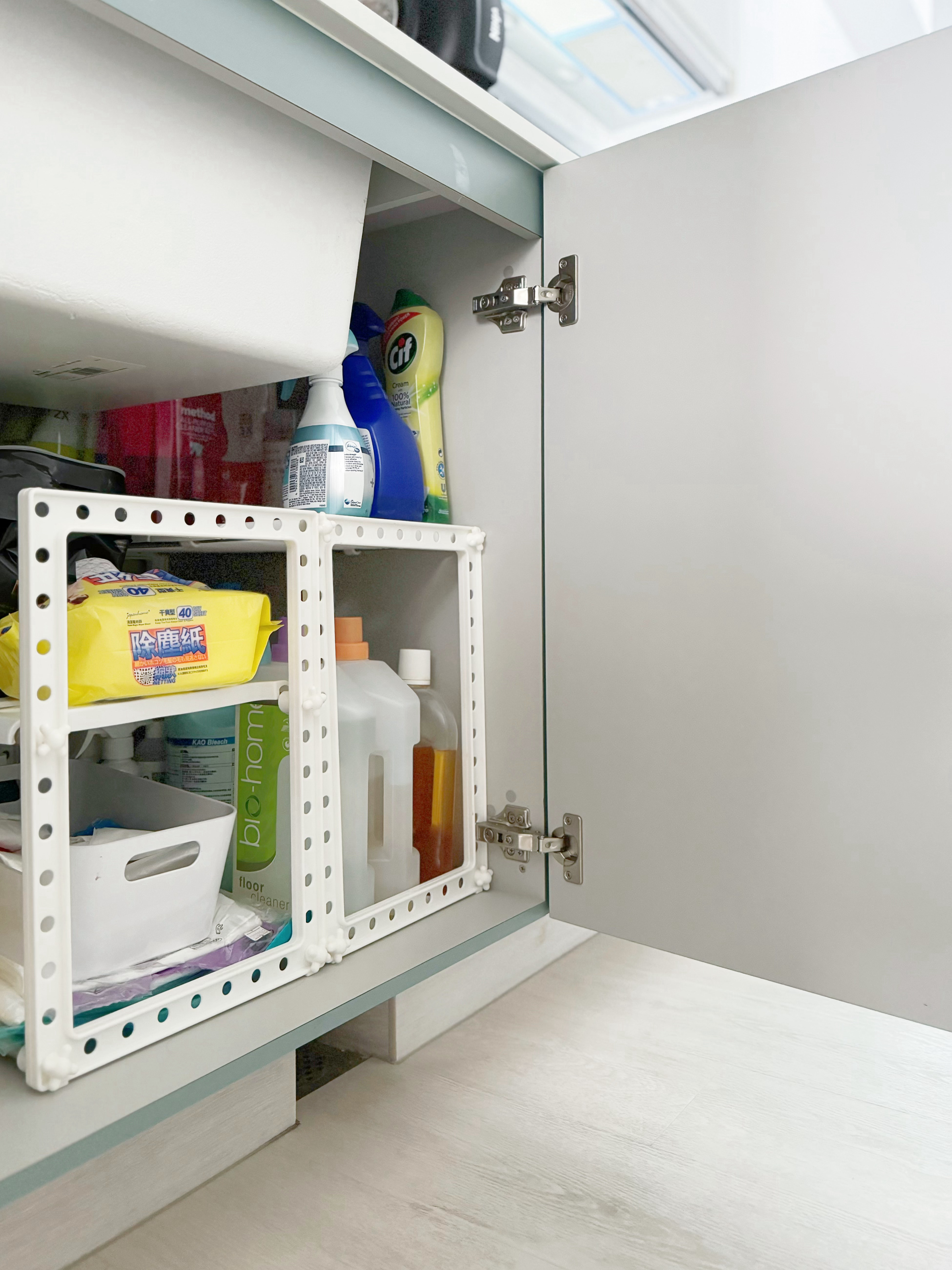 A Small but Efficient Laundry Area - Glass-front cabinet, neatly organized, white interior, open shelf, cleaning supplies