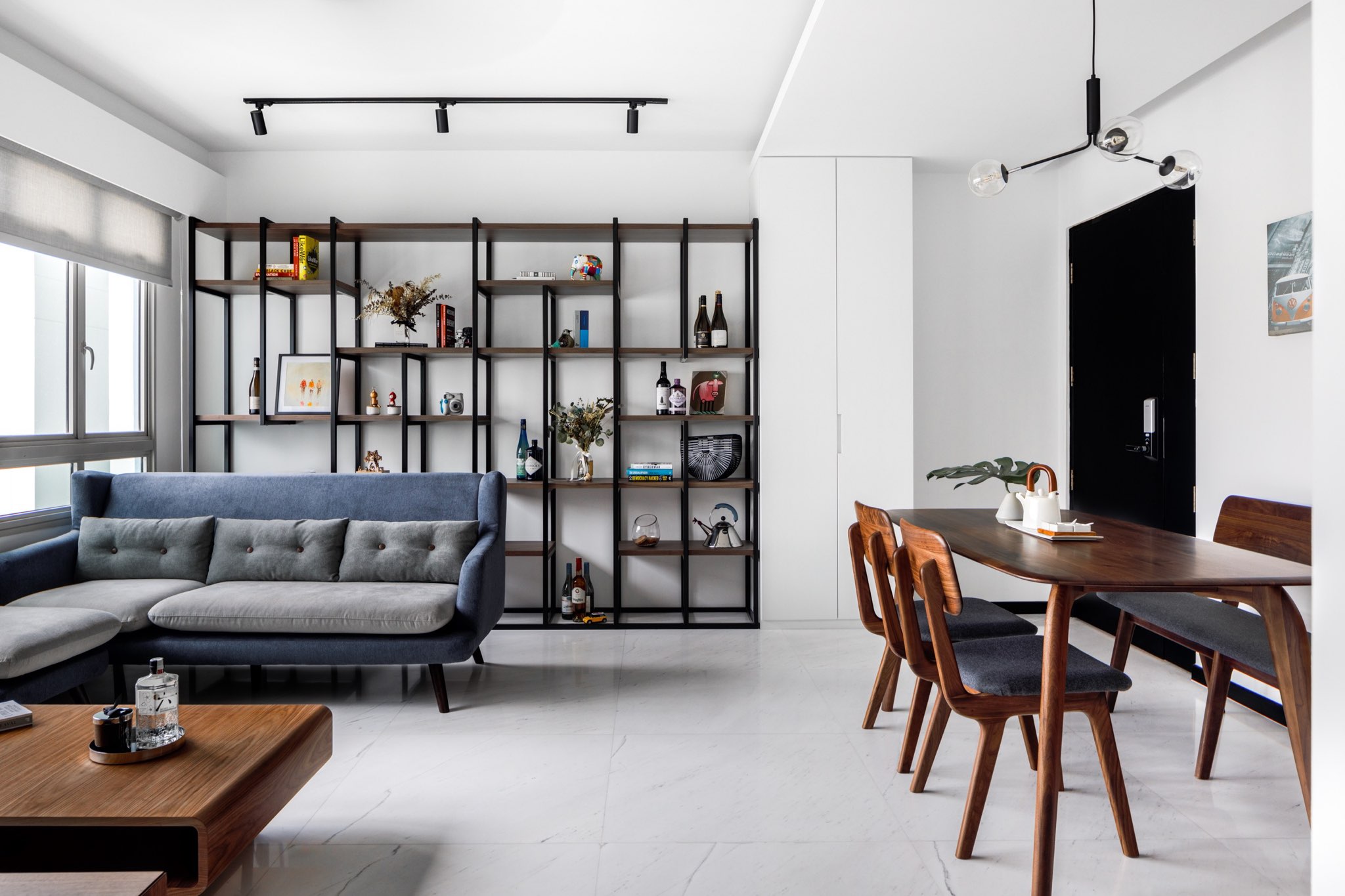 A Minimalist & Industrial Look For A Young Couple - Modern living room with sleek black shelving unit, blue accent sofa